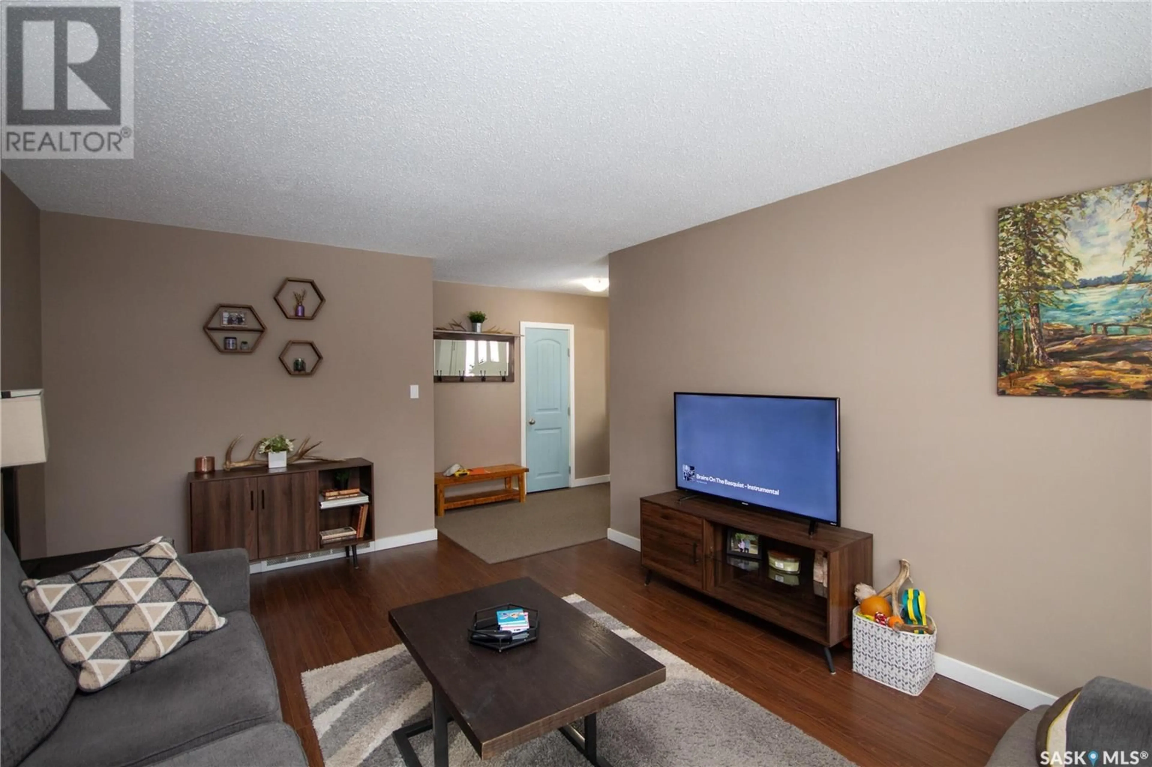 Living room with furniture, wood/laminate floor for 1751 93rd STREET, North Battleford Saskatchewan S9A0C7