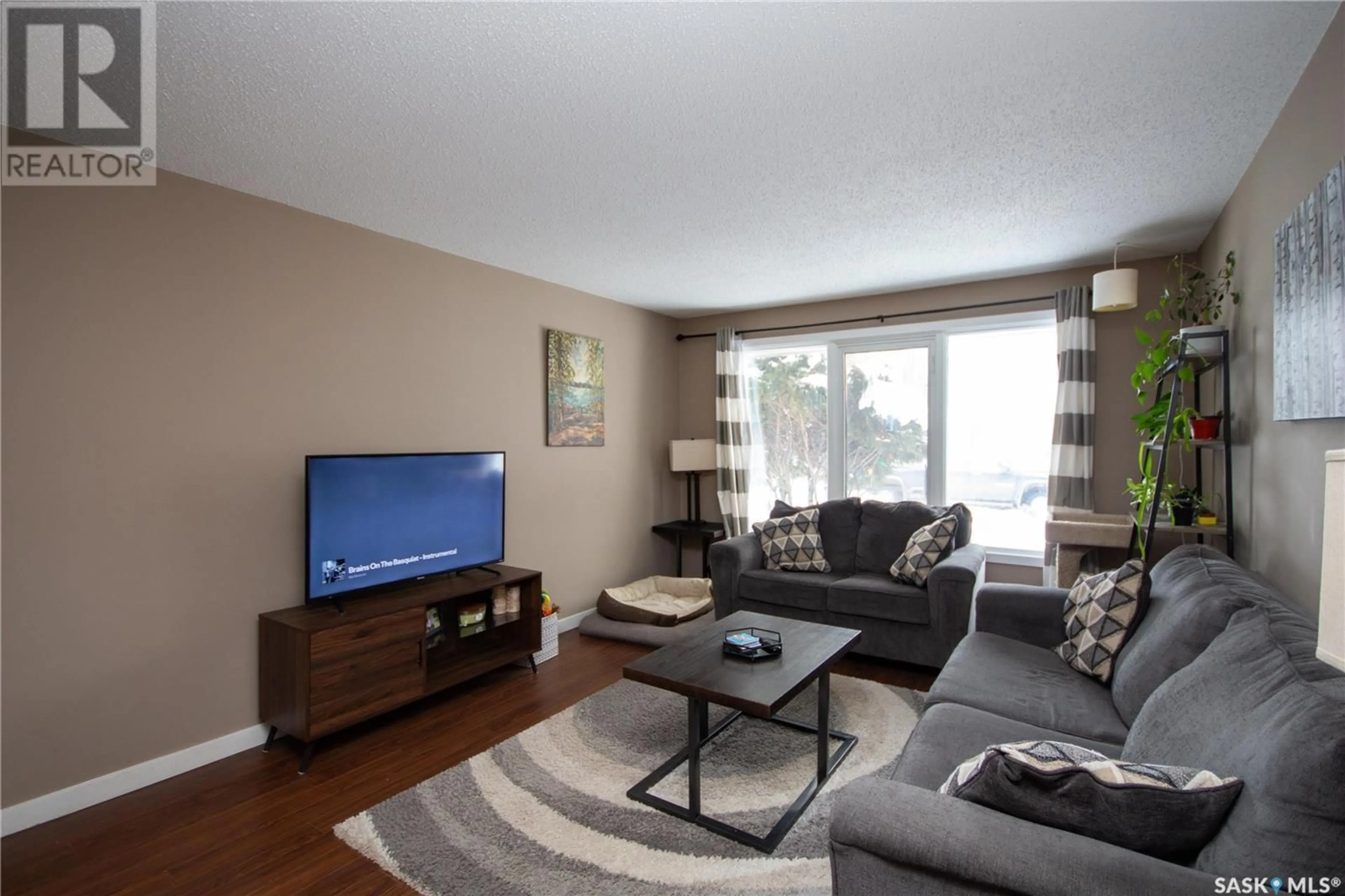 Living room with furniture, wood/laminate floor for 1751 93rd STREET, North Battleford Saskatchewan S9A0C7