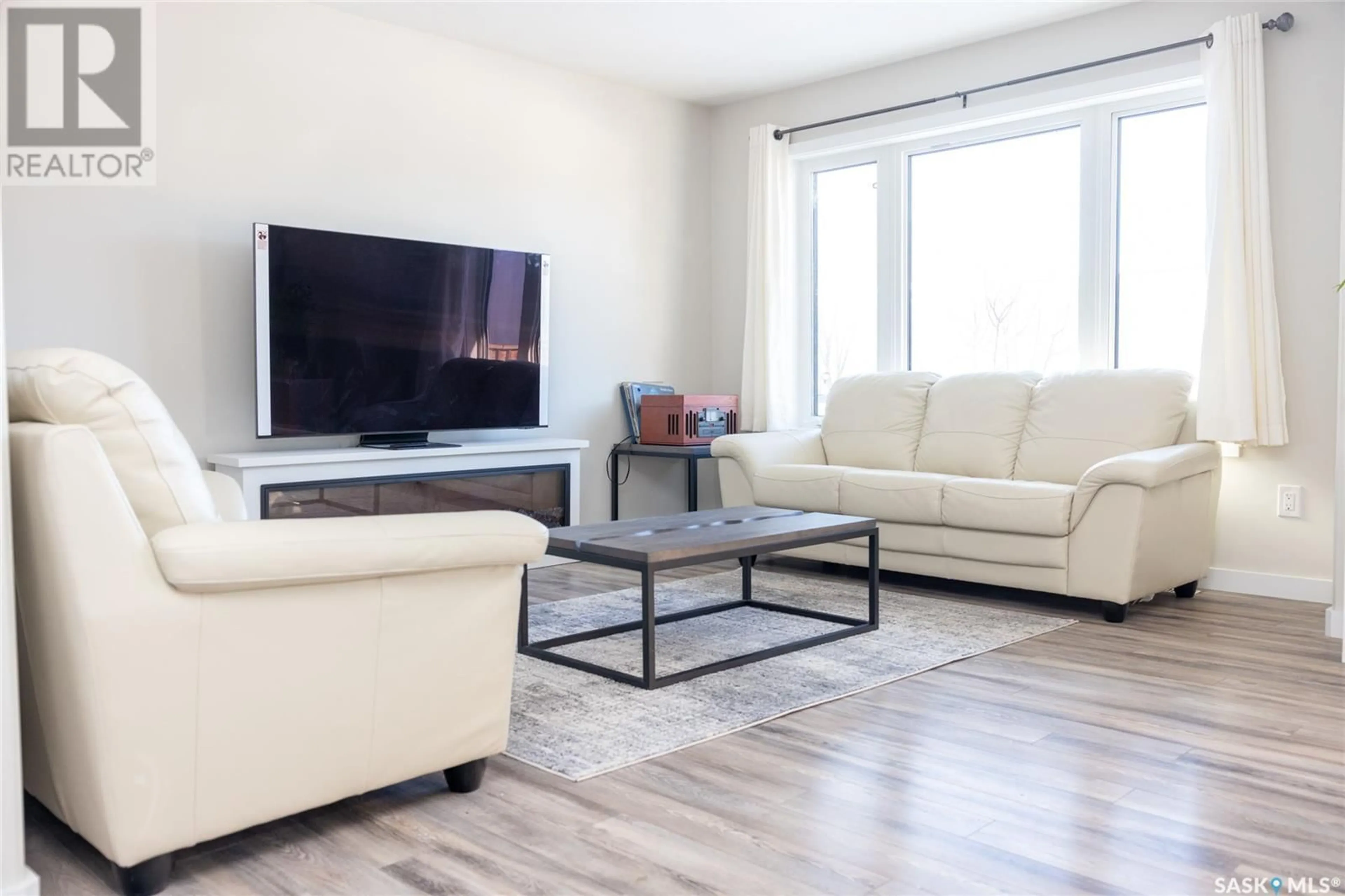 Living room with furniture, wood/laminate floor for 409 Langer PLACE, Warman Saskatchewan S0K4S1