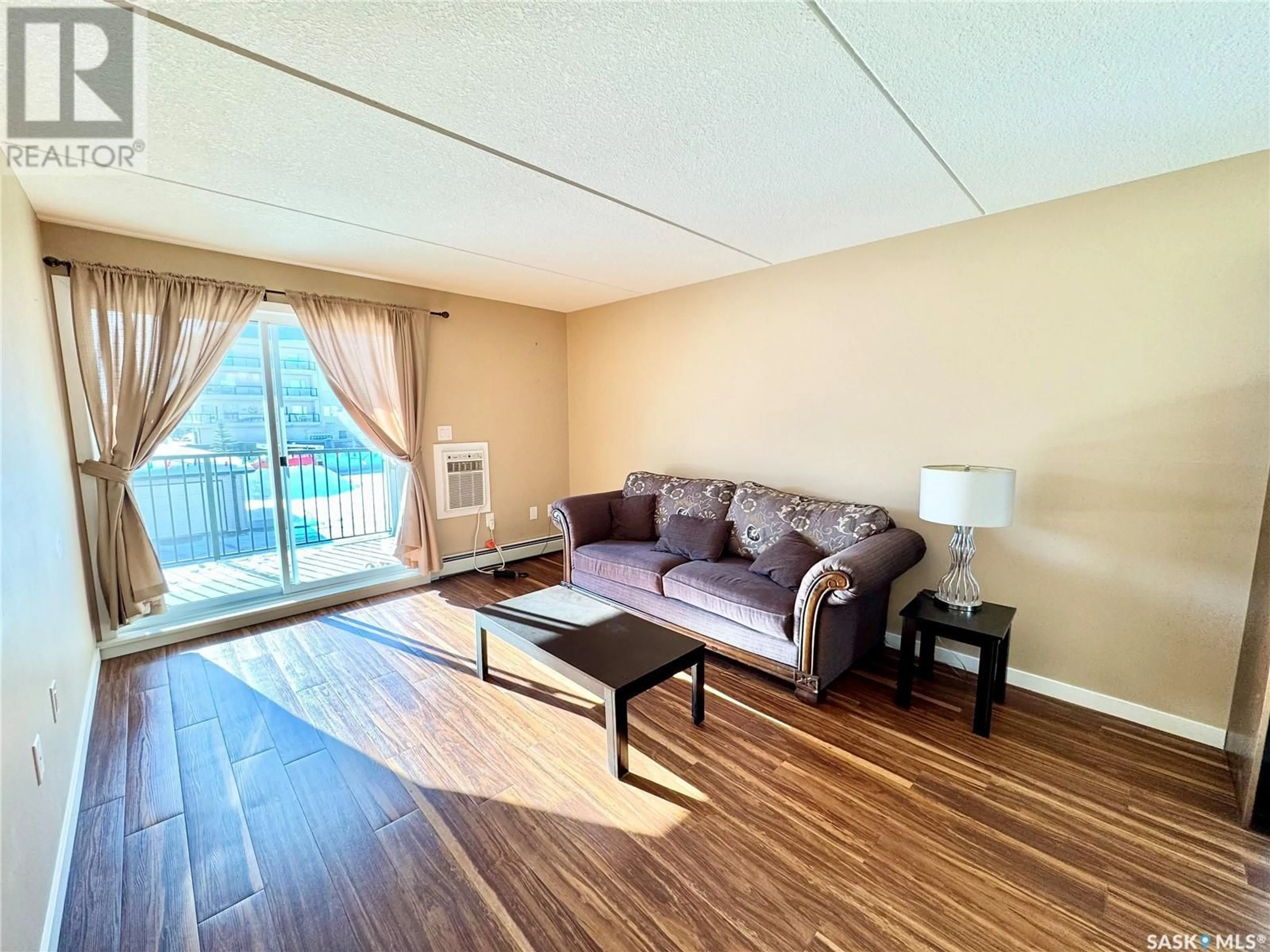 Living room with furniture, wood/laminate floor for 201 - 2761 WOODBRIDGE DRIVE, Prince Albert Saskatchewan S6V3Z9
