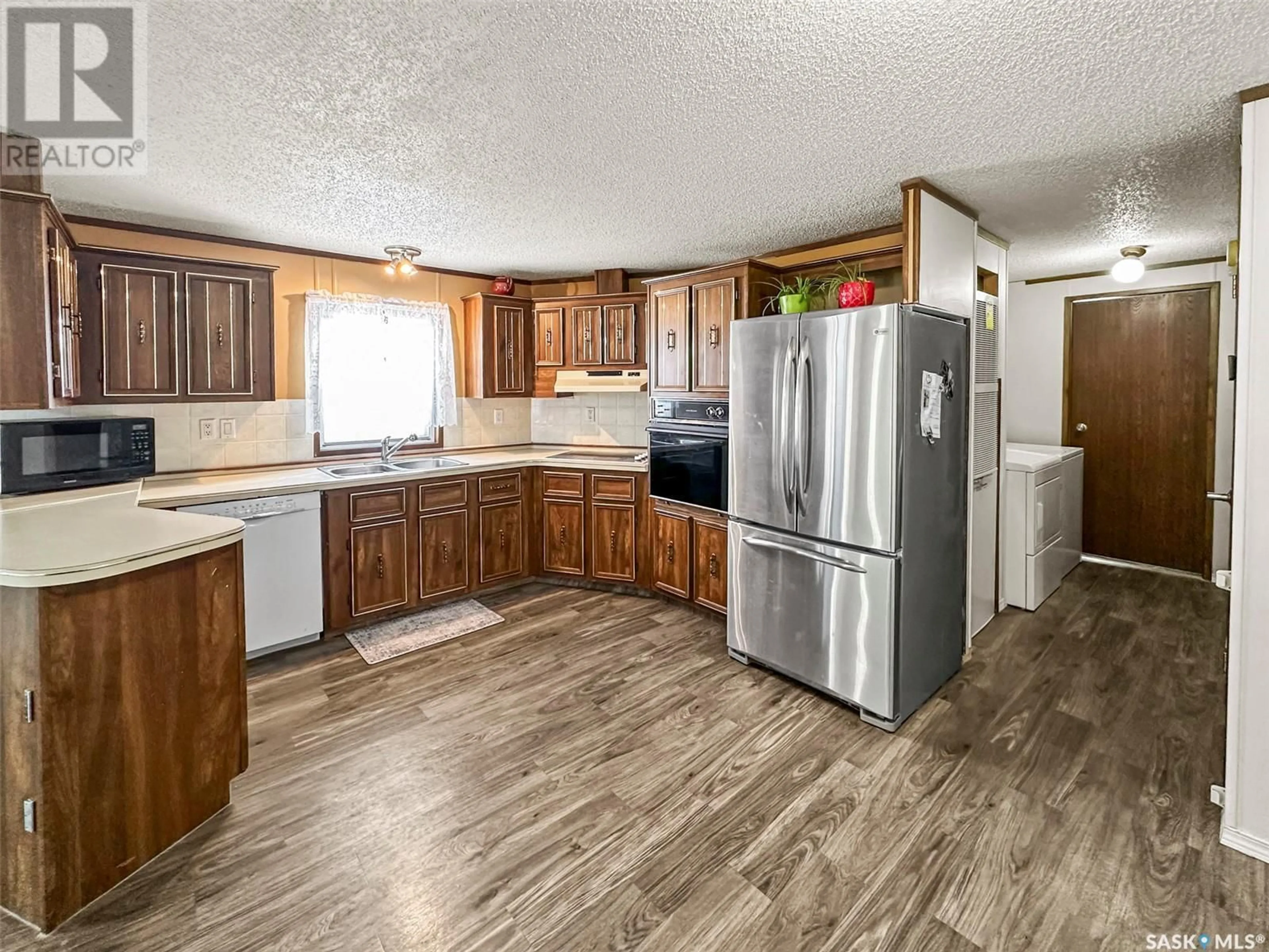 Open concept kitchen, wood/laminate floor for 27 Prairie Sun COURT, Swift Current Saskatchewan S9H3X6