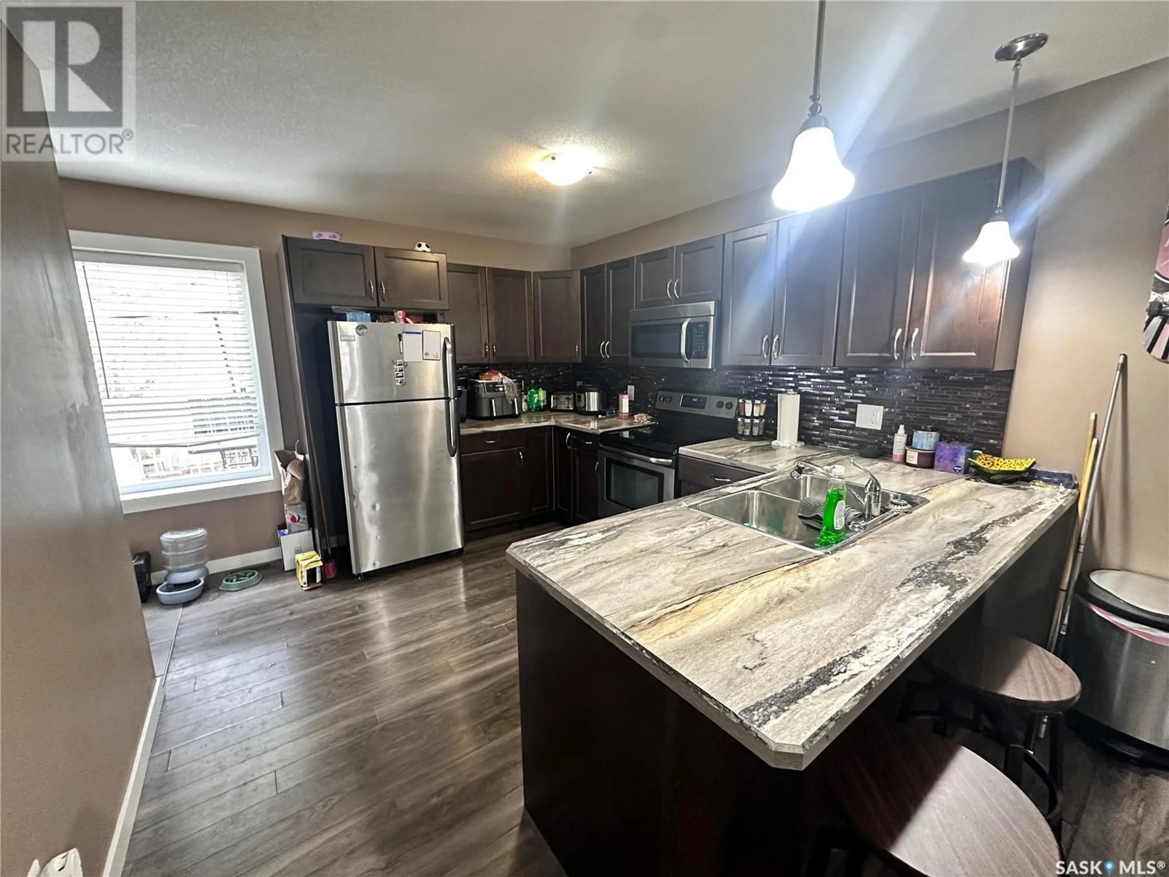 Open concept kitchen, wood/laminate floor for 527 Alexandra STREET, Weyburn Saskatchewan S4H1R7