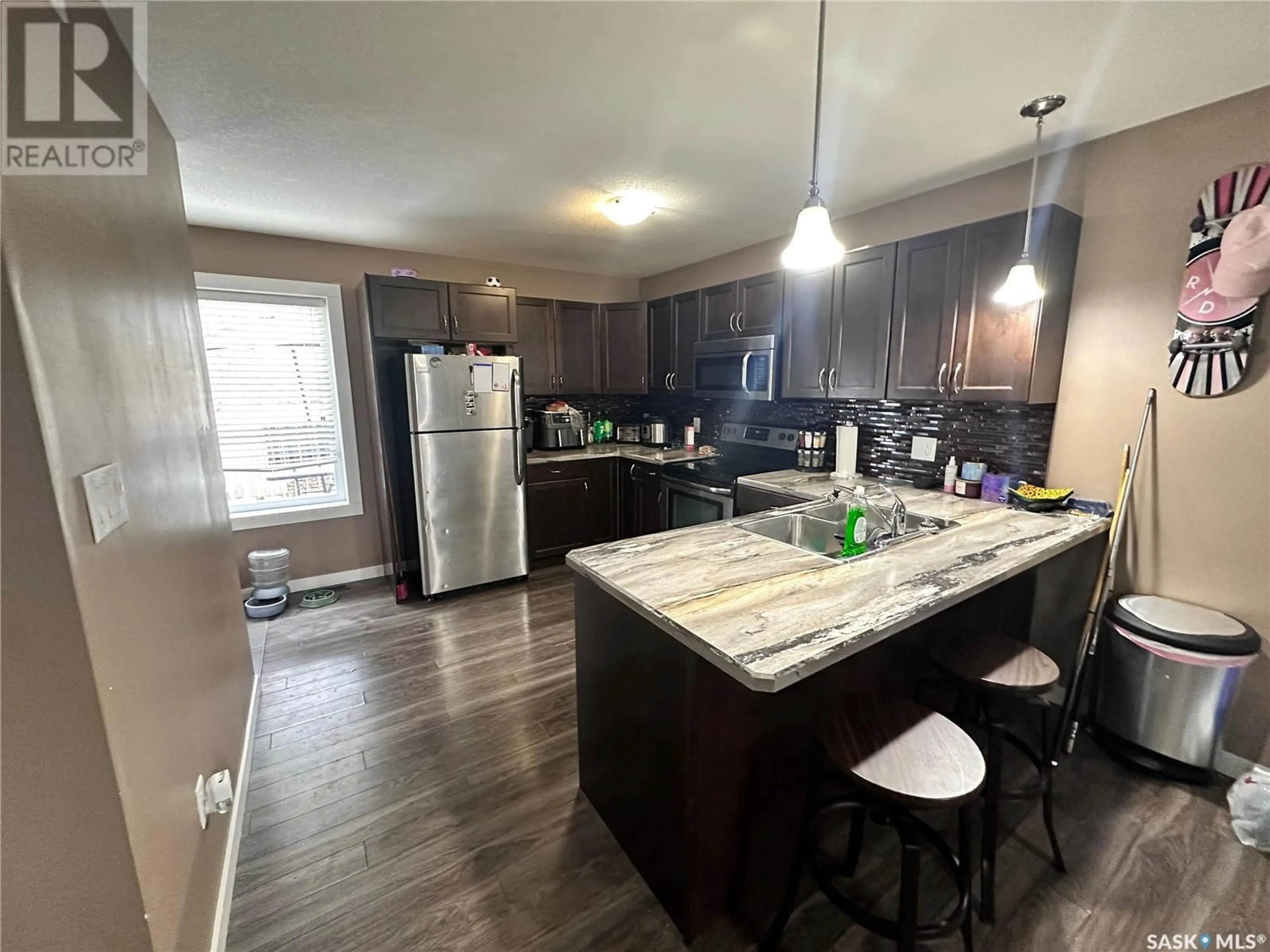 Open concept kitchen, wood/laminate floor for 527 Alexandra STREET, Weyburn Saskatchewan S4H1R7