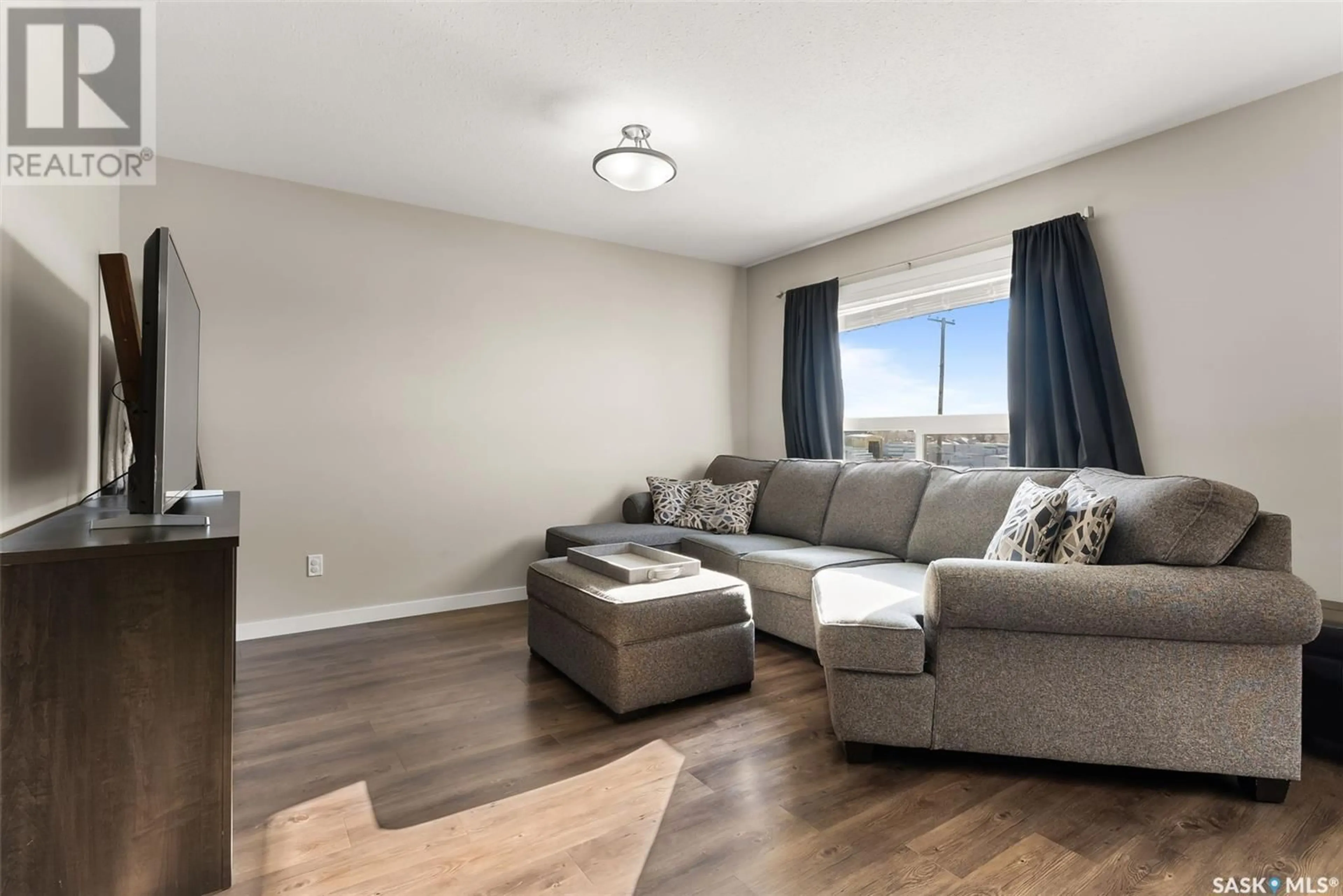 Living room with furniture, wood/laminate floor for 404 2 Savanna CRESCENT, Pilot Butte Saskatchewan S0G3Z0