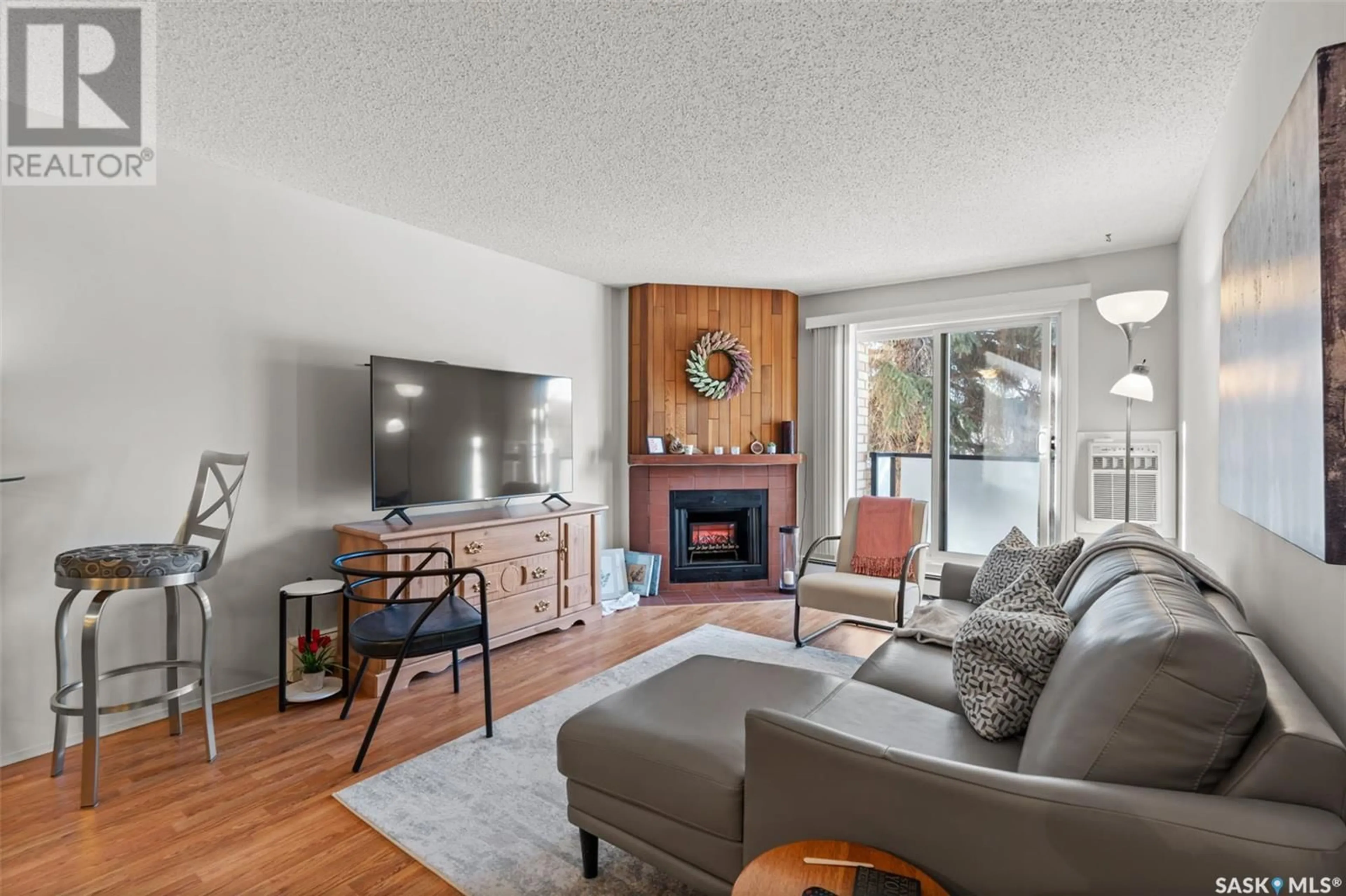 Living room with furniture, wood/laminate floor for 201 415 Tait COURT, Saskatoon Saskatchewan S7H5L3