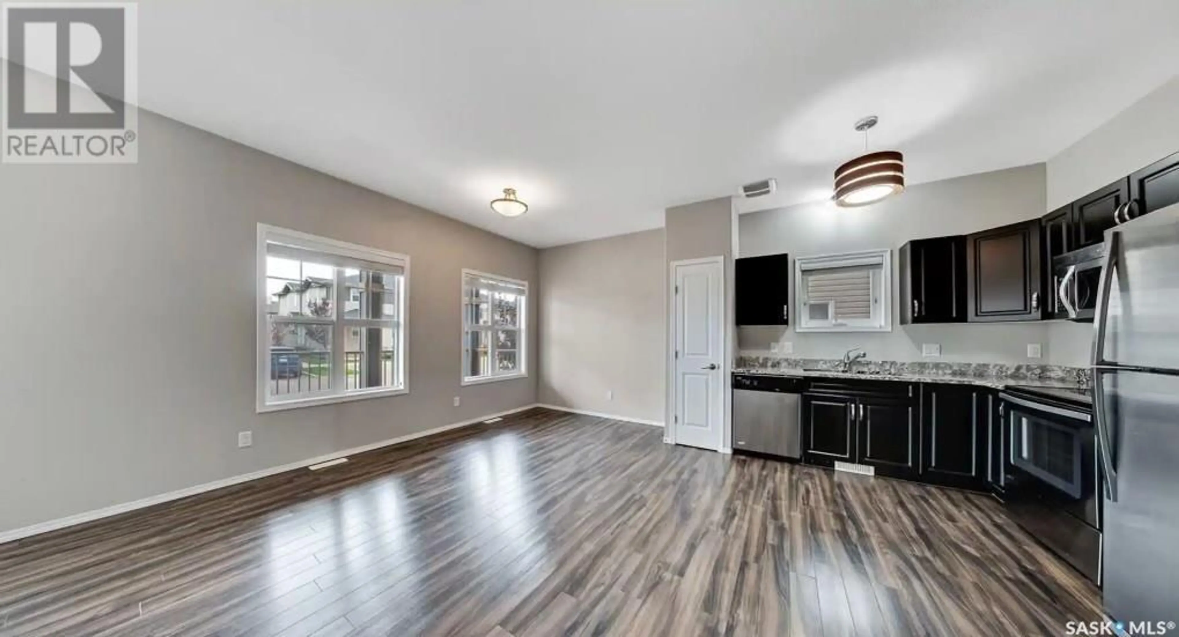 Open concept kitchen, wood/laminate floor for 113 100 Chaparral BOULEVARD, Martensville Saskatchewan S0K0A2