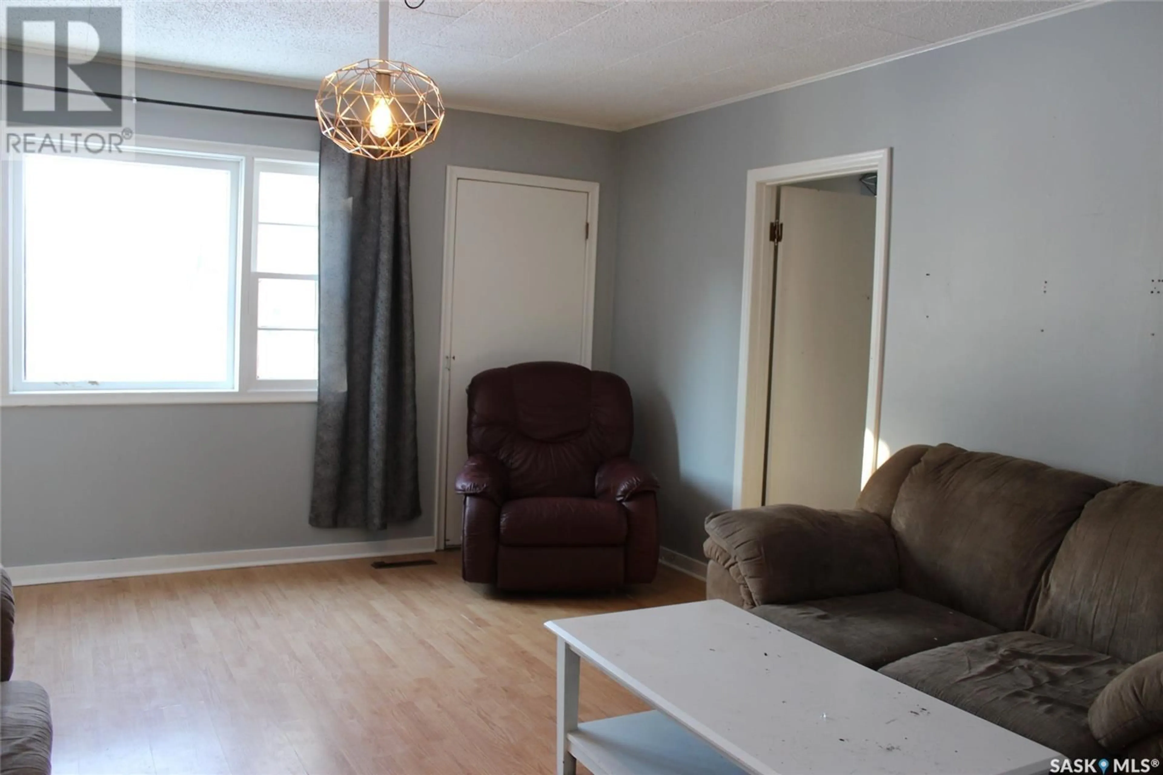 Living room with furniture, wood/laminate floor for 724 3RD STREET, Shaunavon Saskatchewan S0N2M0