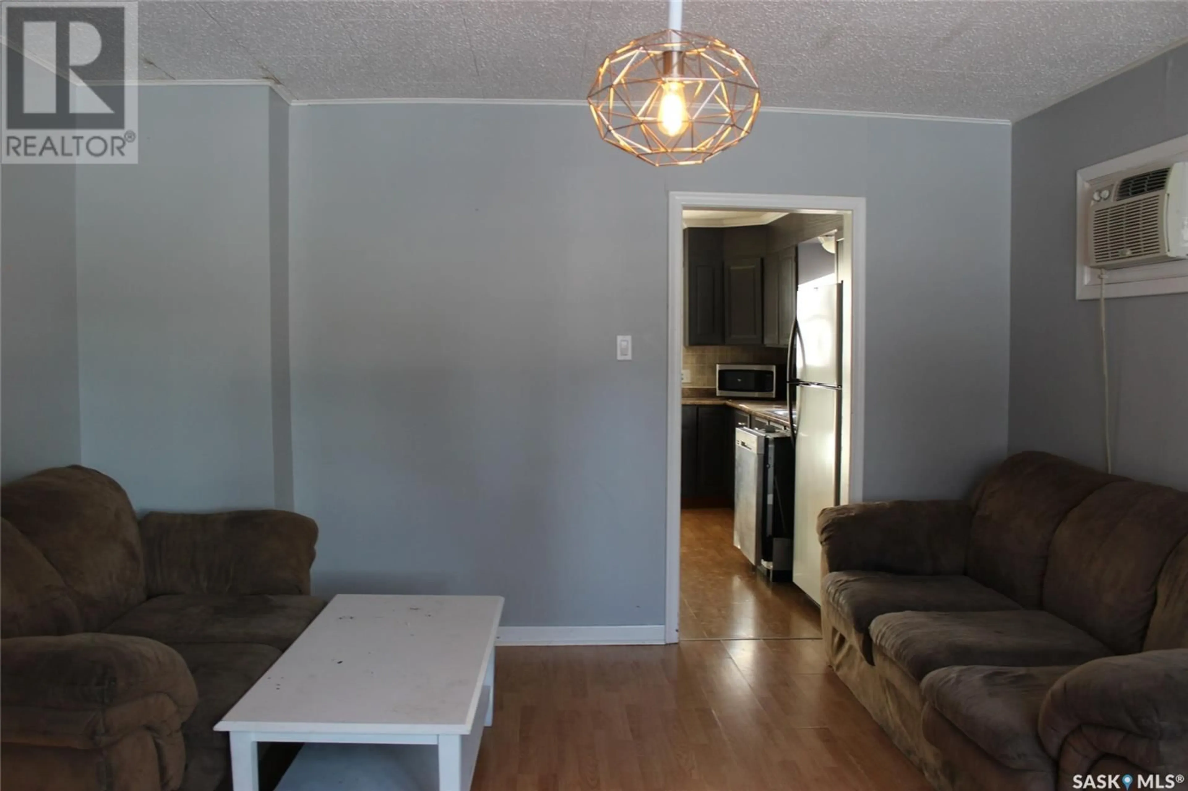 Living room with furniture, wood/laminate floor for 724 3RD STREET, Shaunavon Saskatchewan S0N2M0