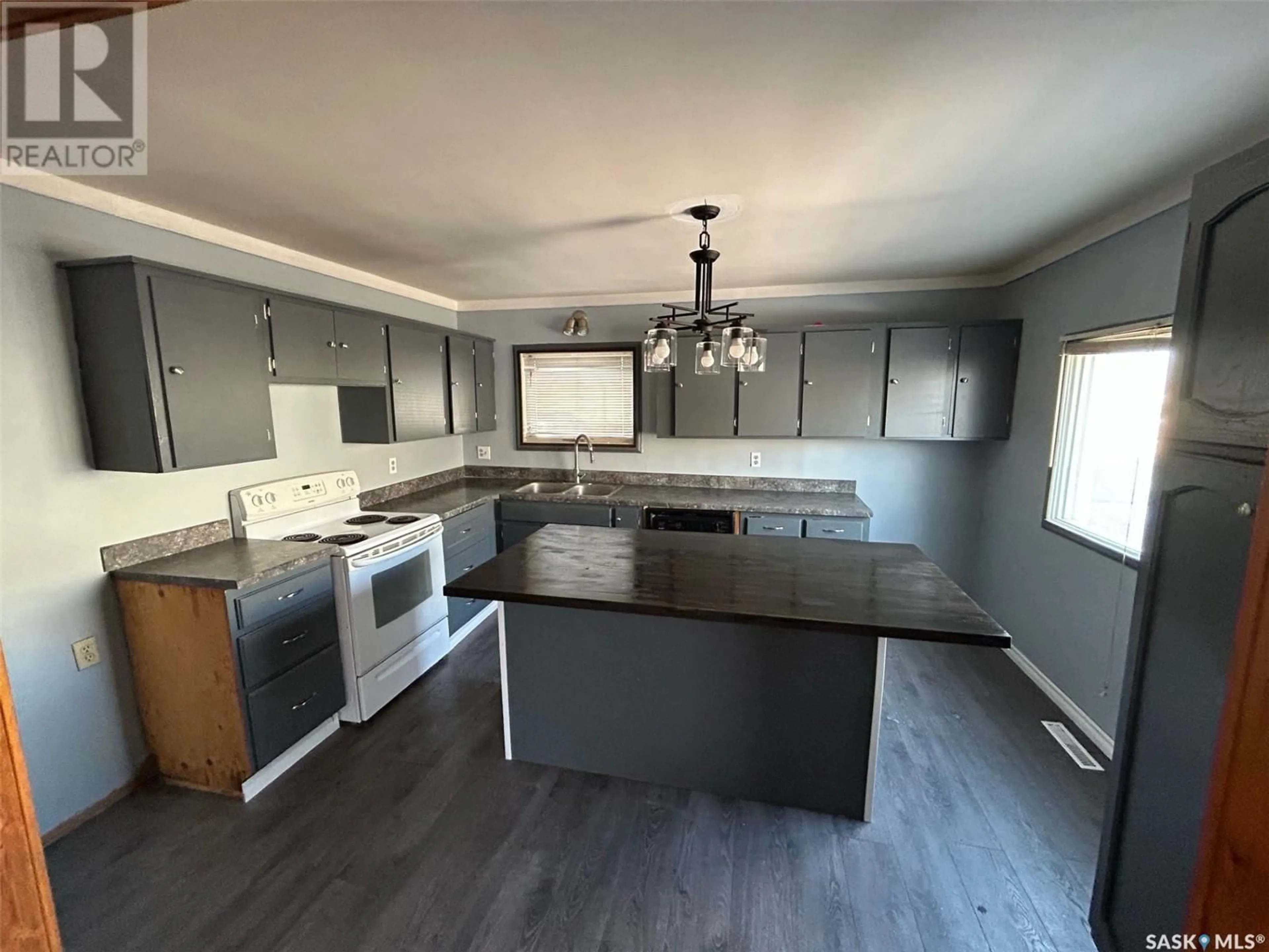 Open concept kitchen, wood/laminate floor for 211 4th AVENUE W, Assiniboia Saskatchewan S0H0B0