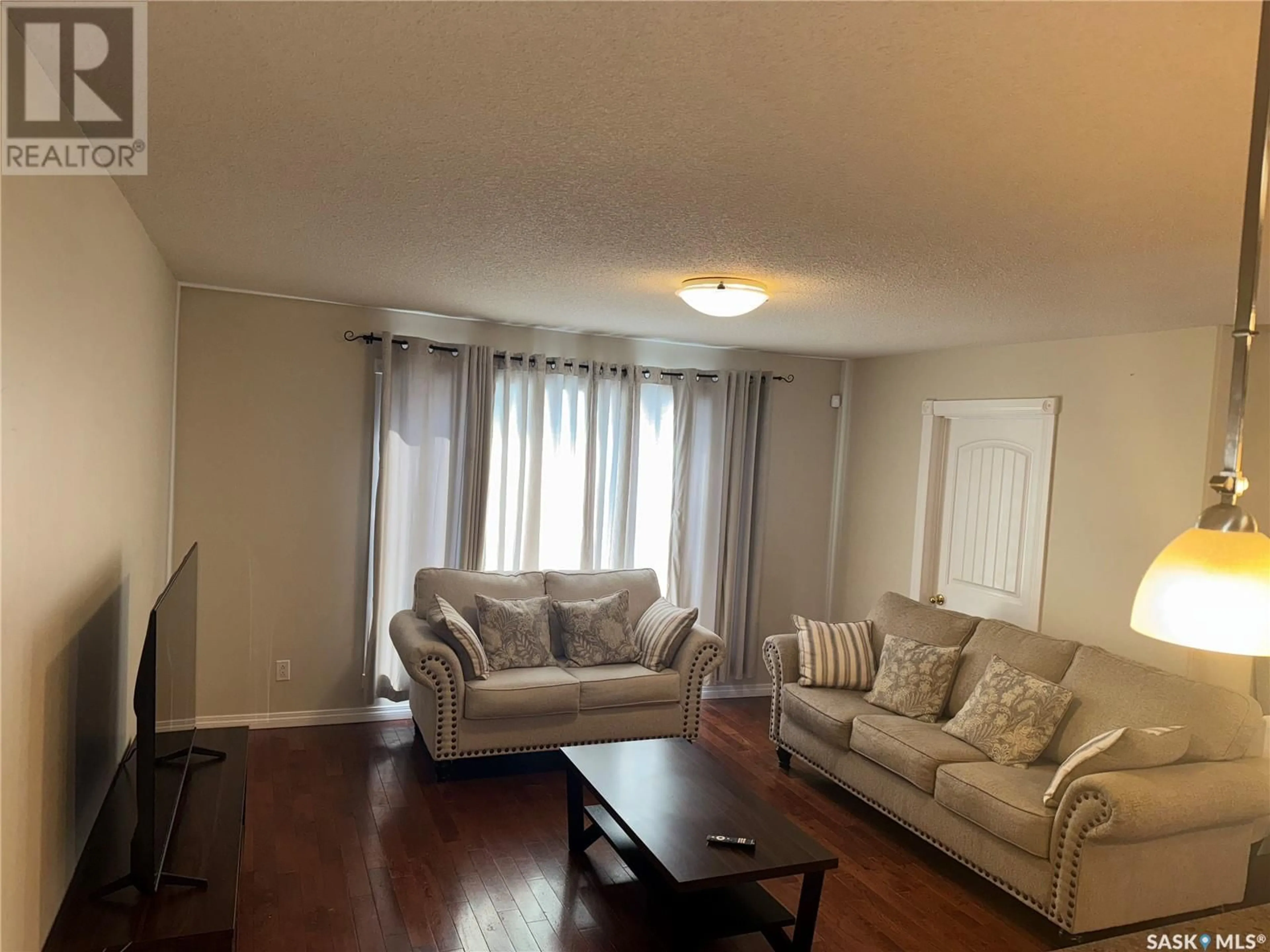 Living room with furniture, wood/laminate floor for 1849 Atkinson STREET, Regina Saskatchewan S4N3W4