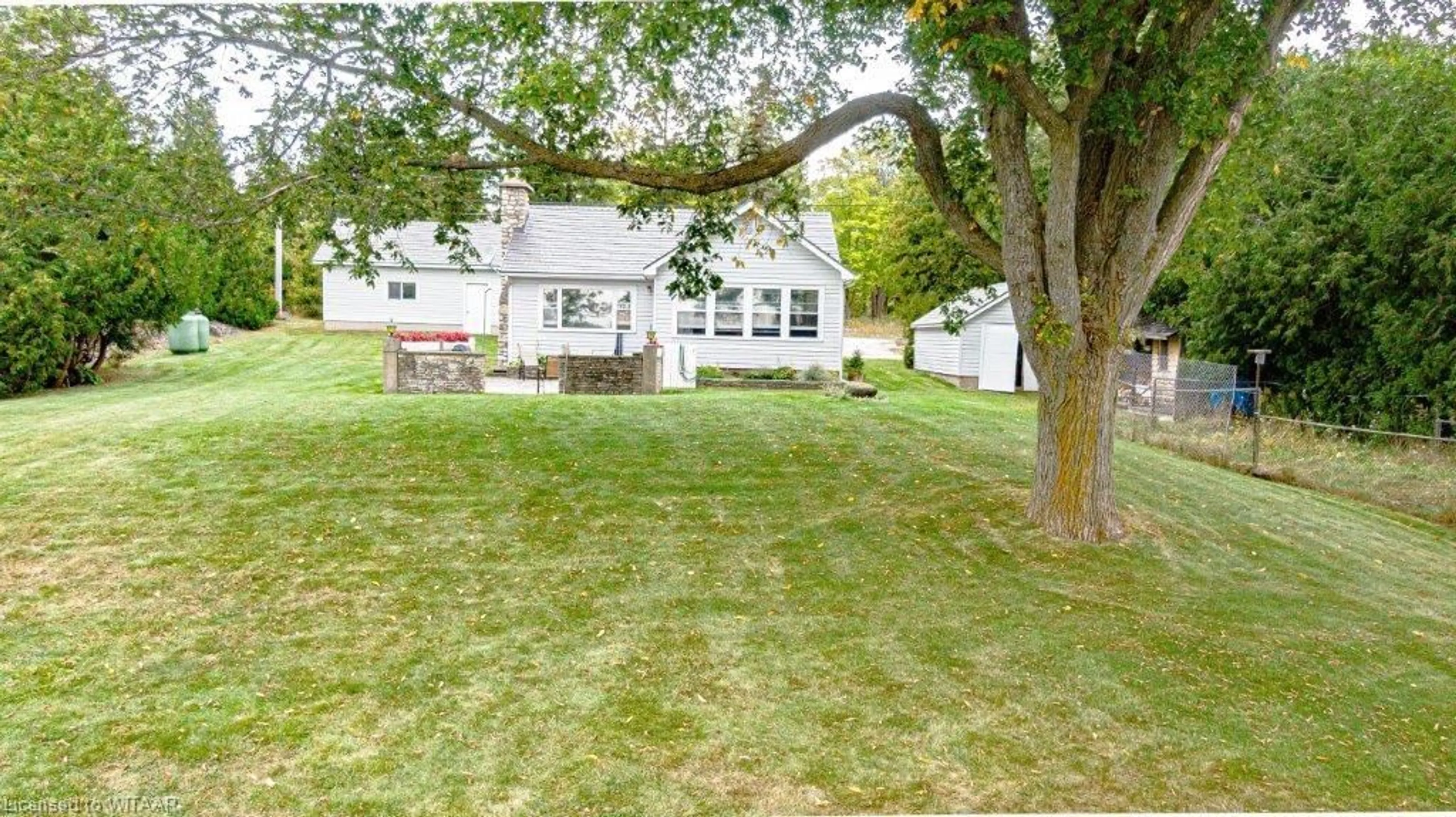 Frontside or backside of a home, the fenced backyard for 117 Tamarac Rd, Stokes Bay Ontario N0H 2M0