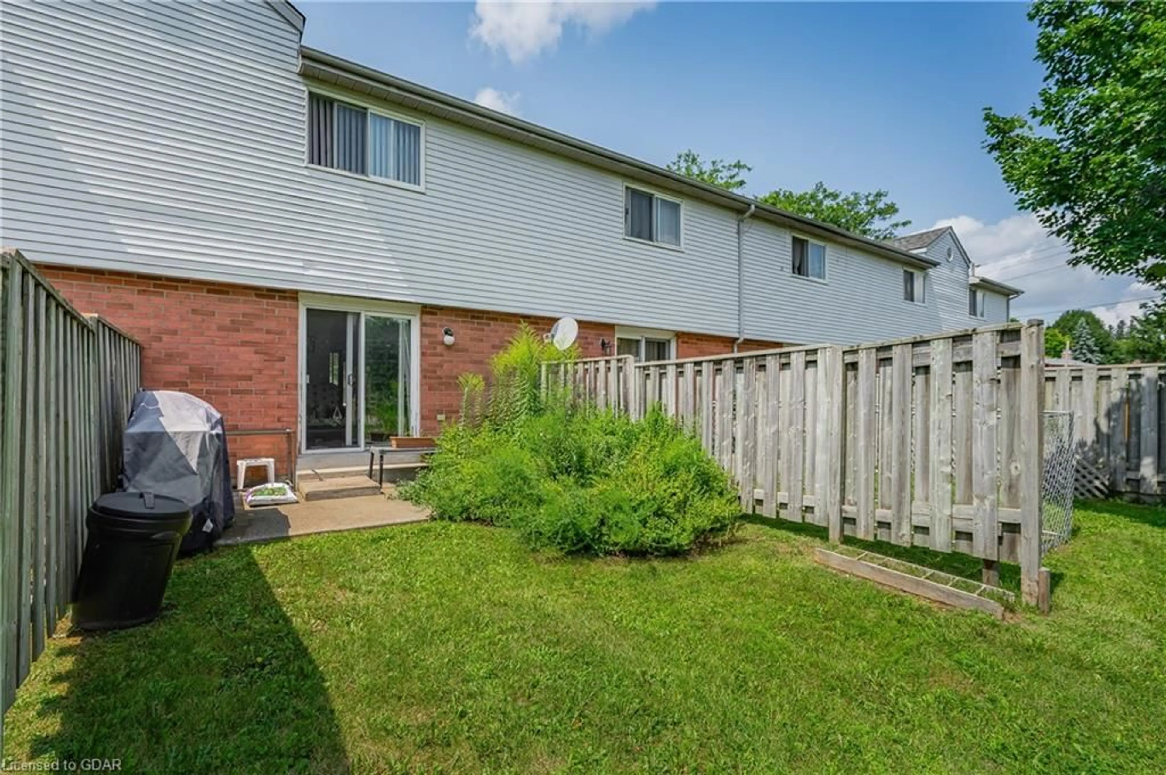 A pic from exterior of the house or condo, the fenced backyard for 40 Imperial Rd #5, Guelph Ontario N1H 8B4