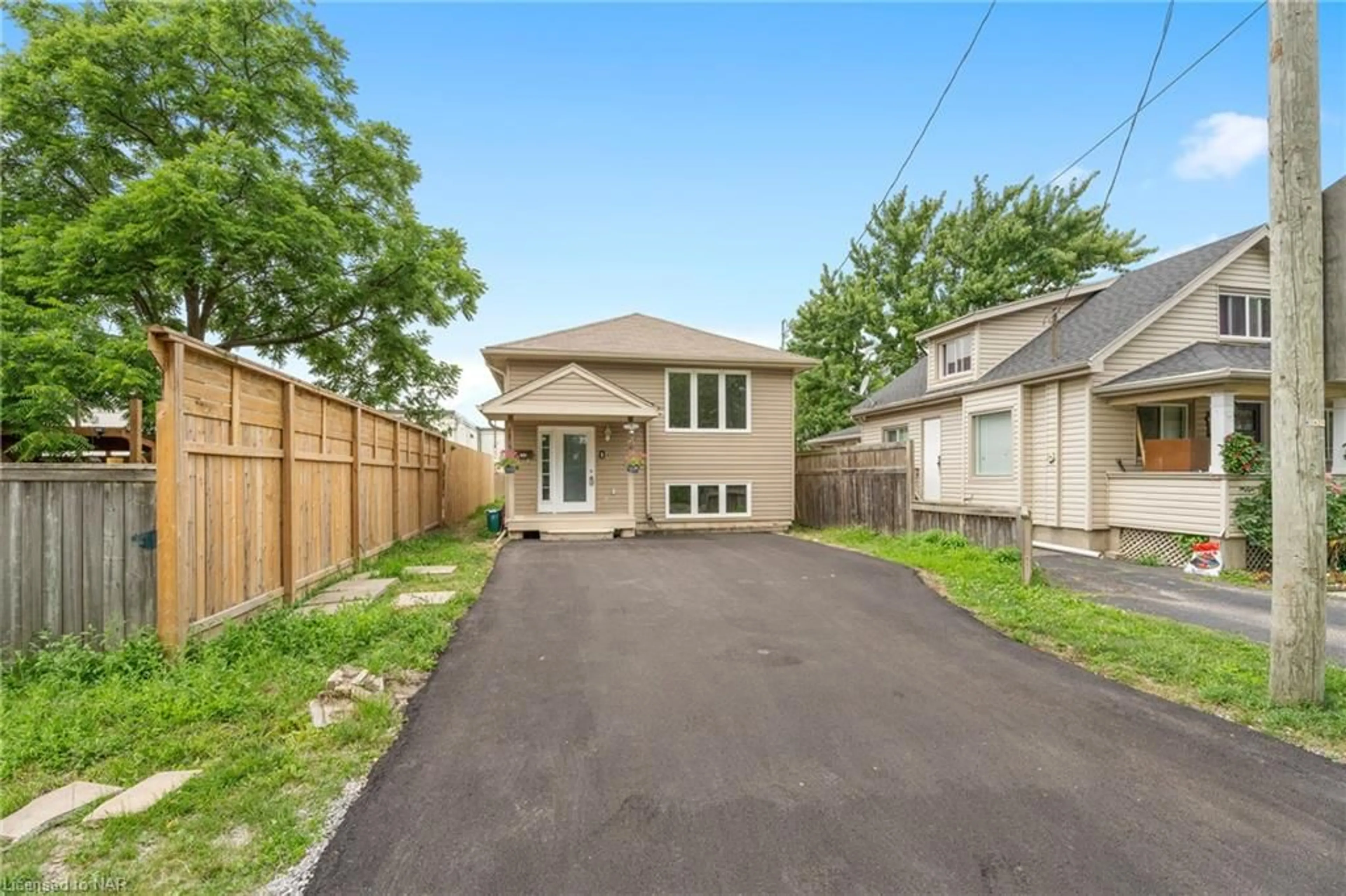 Frontside or backside of a home, the fenced backyard for 1 Thornton St, St. Catharines Ontario L2P 1T9