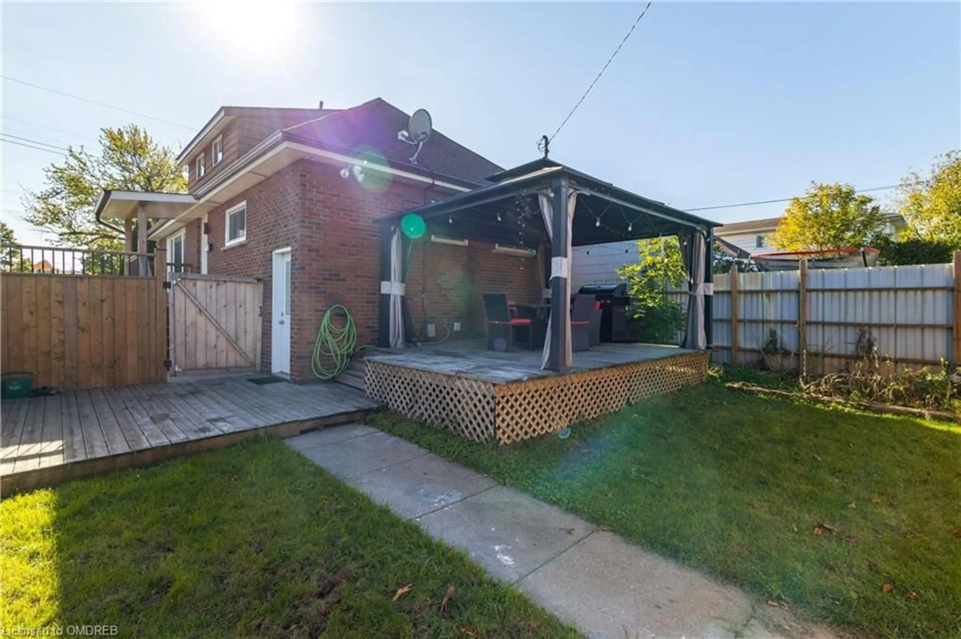 Frontside or backside of a home, the fenced backyard for 55 Allan Ave, Hamilton Ontario L8H 2C8