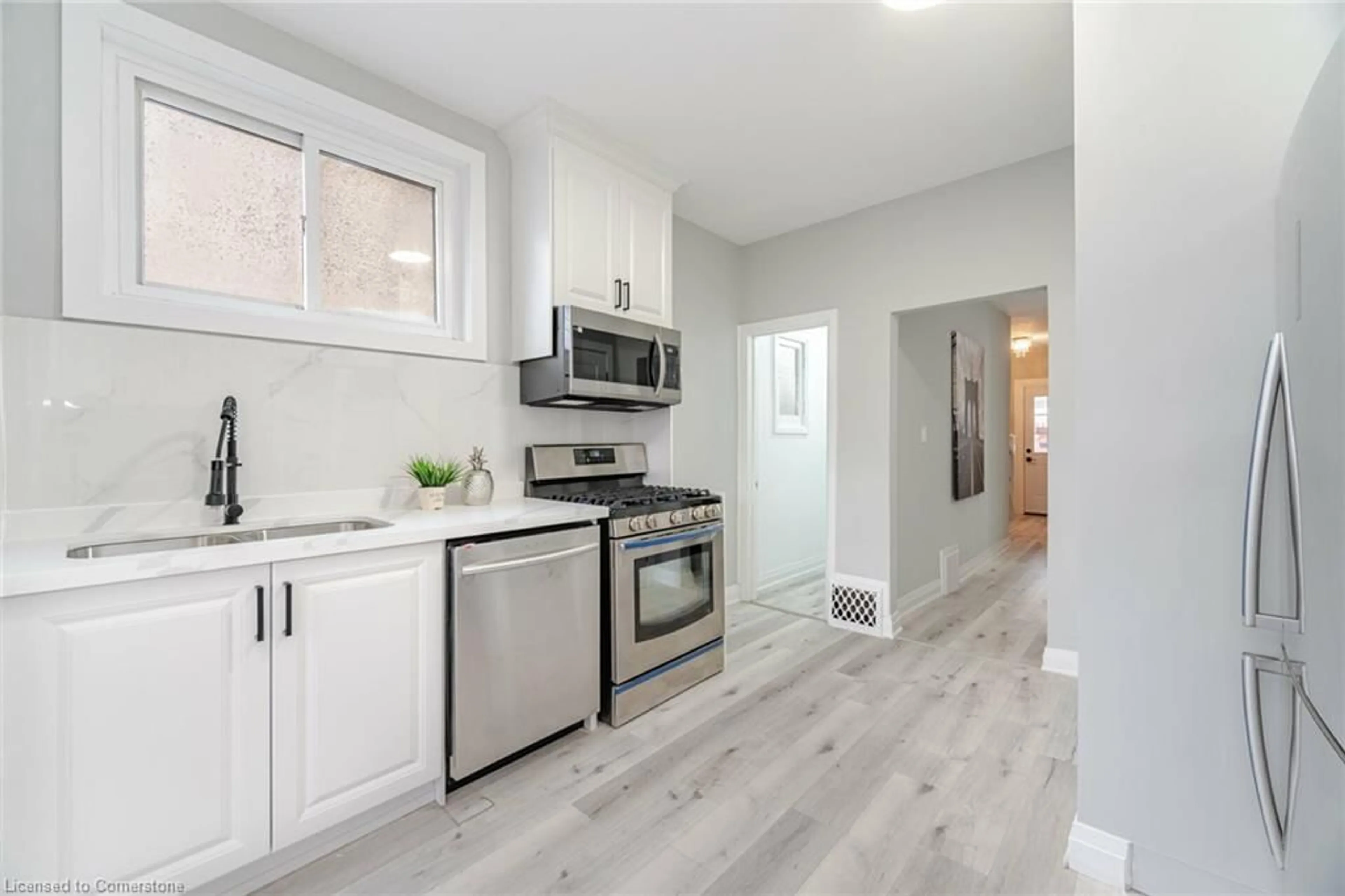 Open concept kitchen, wood/laminate floor for 24 Keith St, Hamilton Ontario L8L 3S1