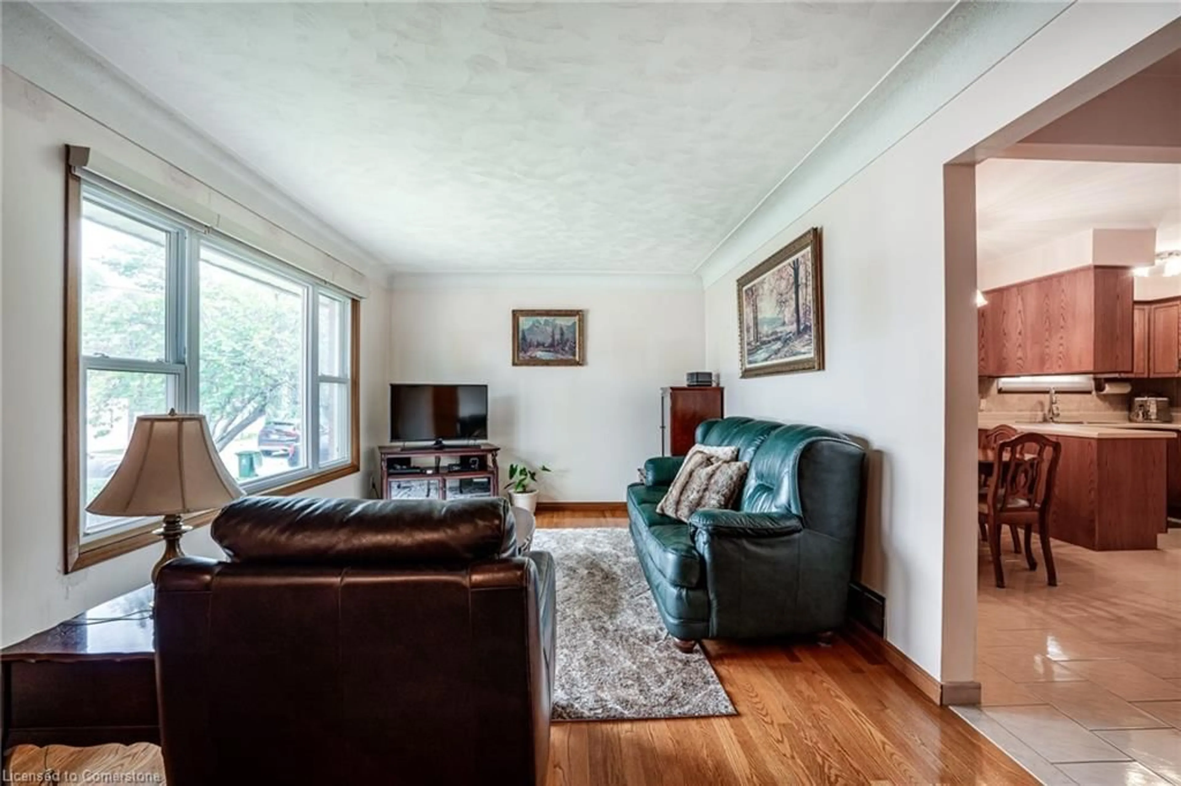 Living room with furniture, wood/laminate floor for 403 Jackson St, Hamilton Ontario L8P 1N3