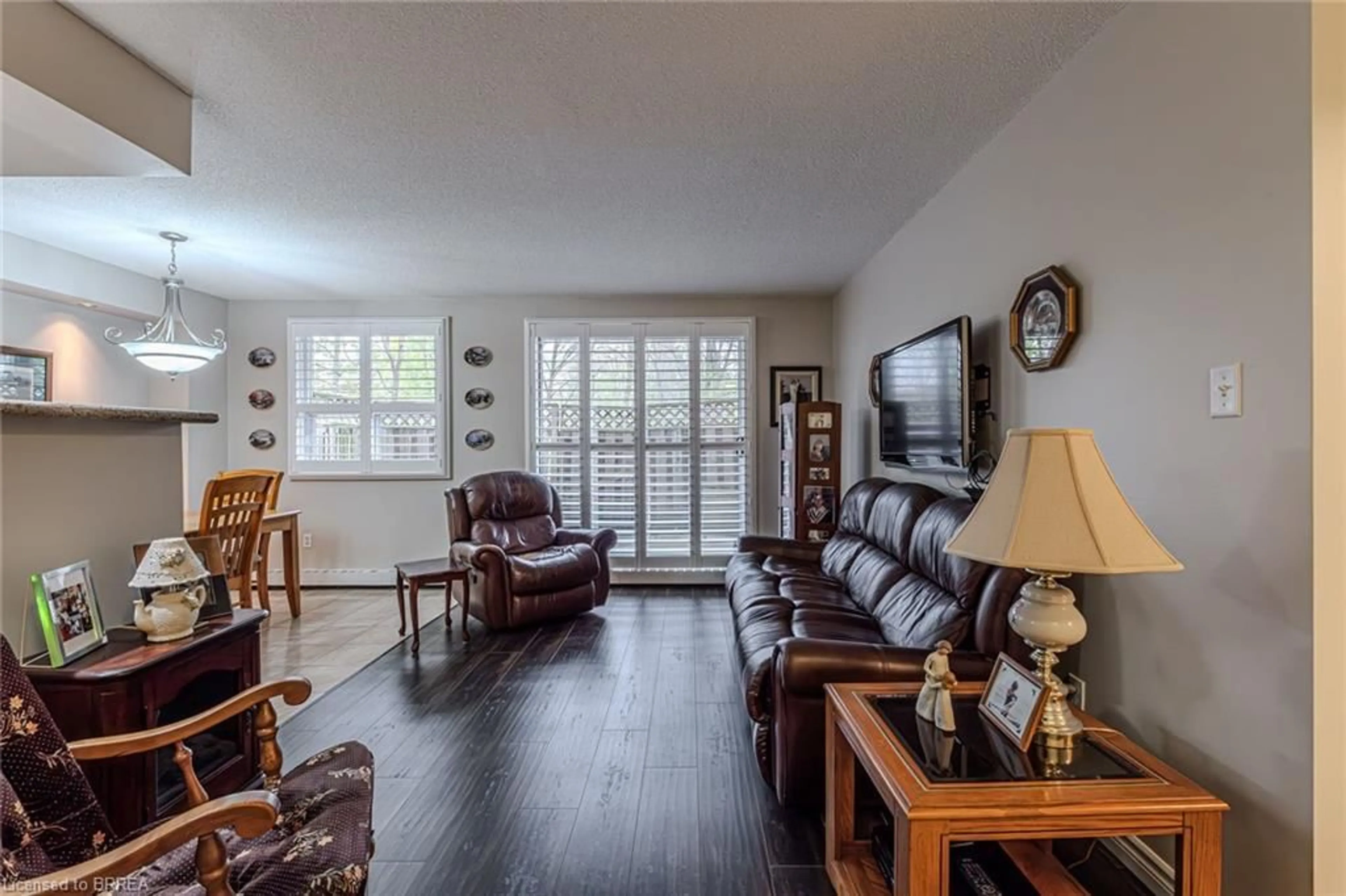 Living room with furniture, wood/laminate floor for 793 Colborne St #117, Brantford Ontario N3S 7J3