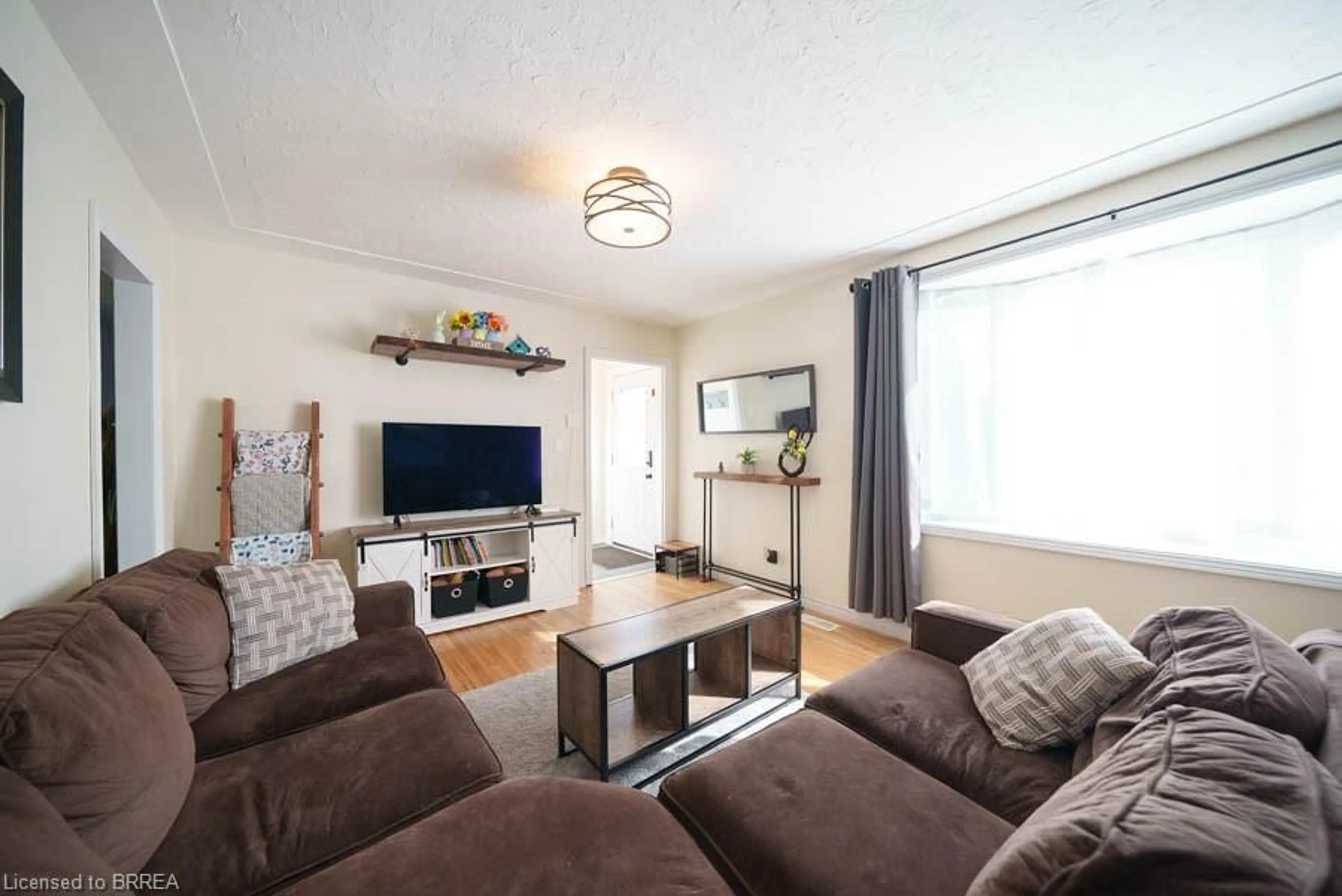 Living room with furniture, wood/laminate floor for 36 James Ave, Brantford Ontario N3S 6Y3