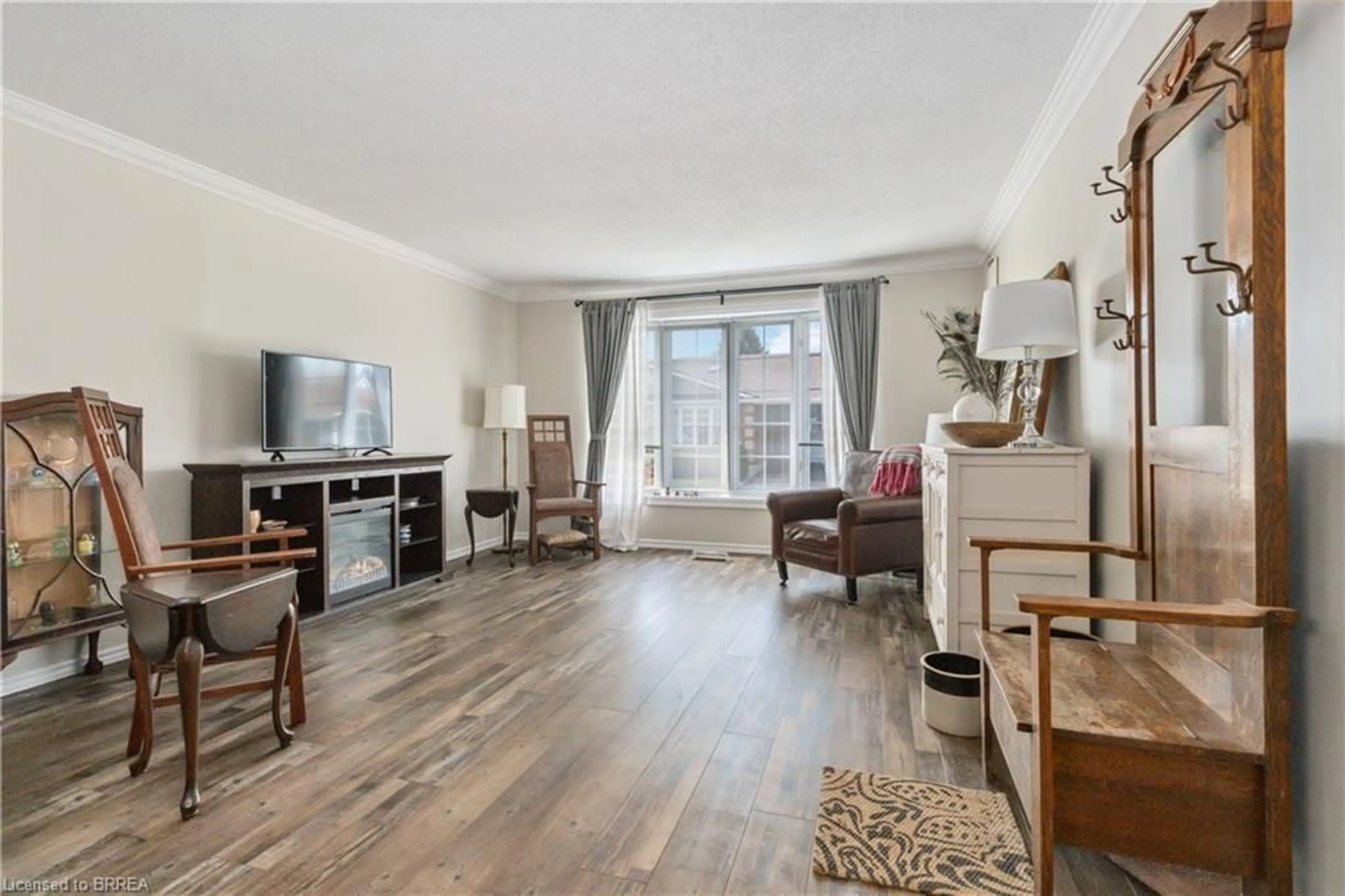 Living room with furniture, wood/laminate floor for 20 Courtland Dr #8, Brantford Ontario N3R 7Y2