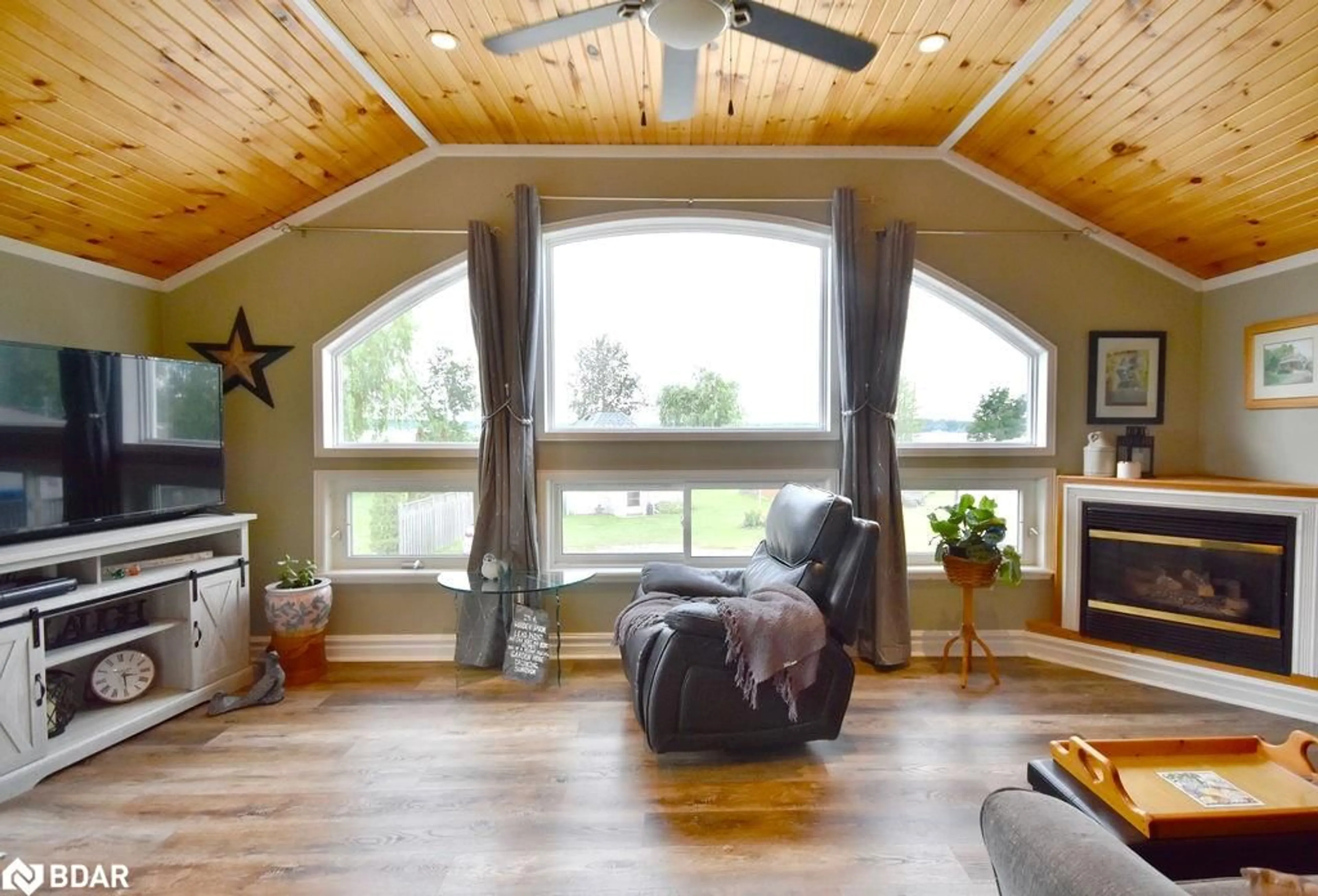 Living room with furniture, wood/laminate floor for 5632 Penetanguishene Rd, Elmvale Ontario L0L 1P0