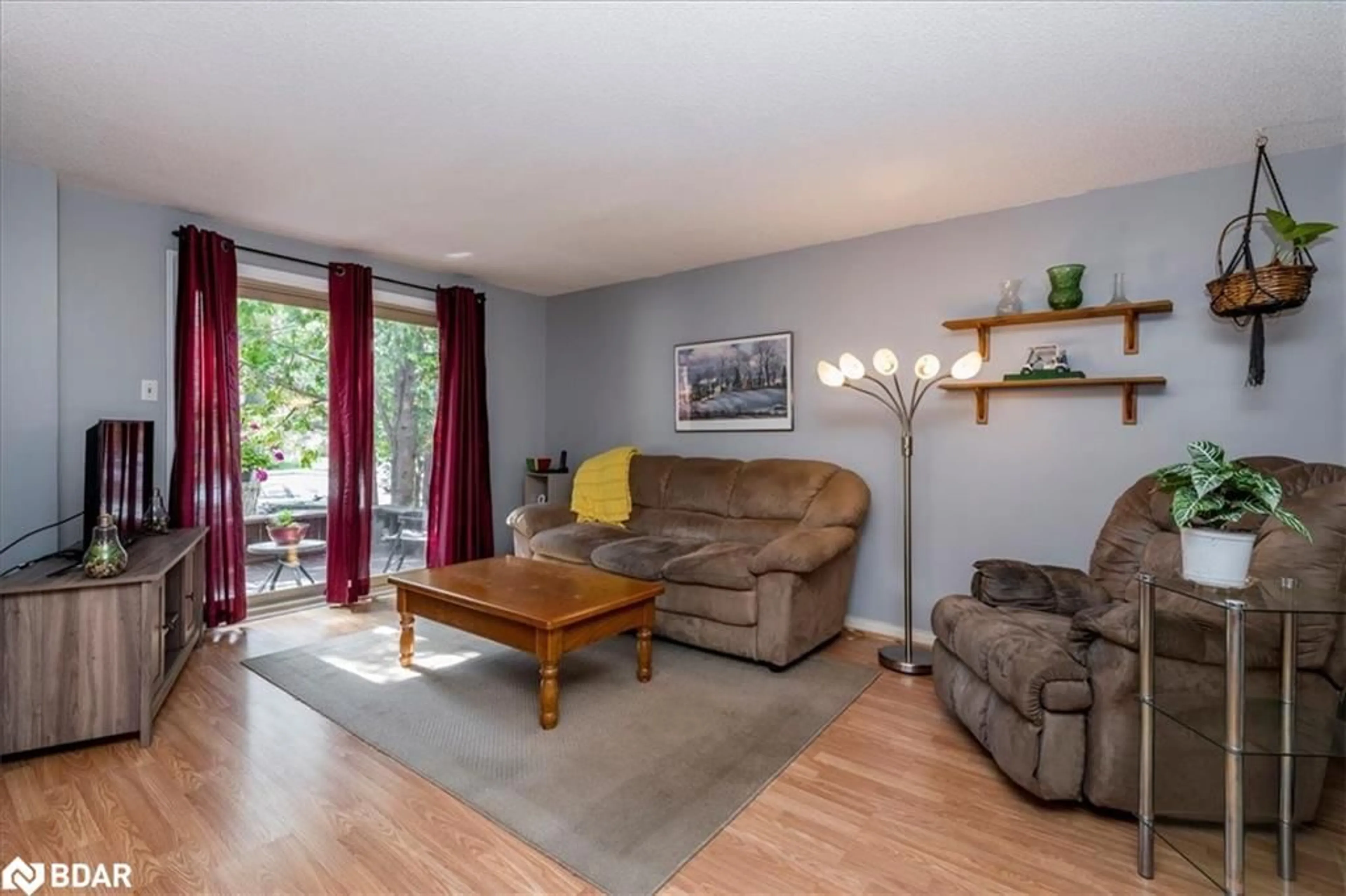 Living room with furniture, wood/laminate floor for 15 Shadowood Rd #103, Barrie Ontario L4N 7K5