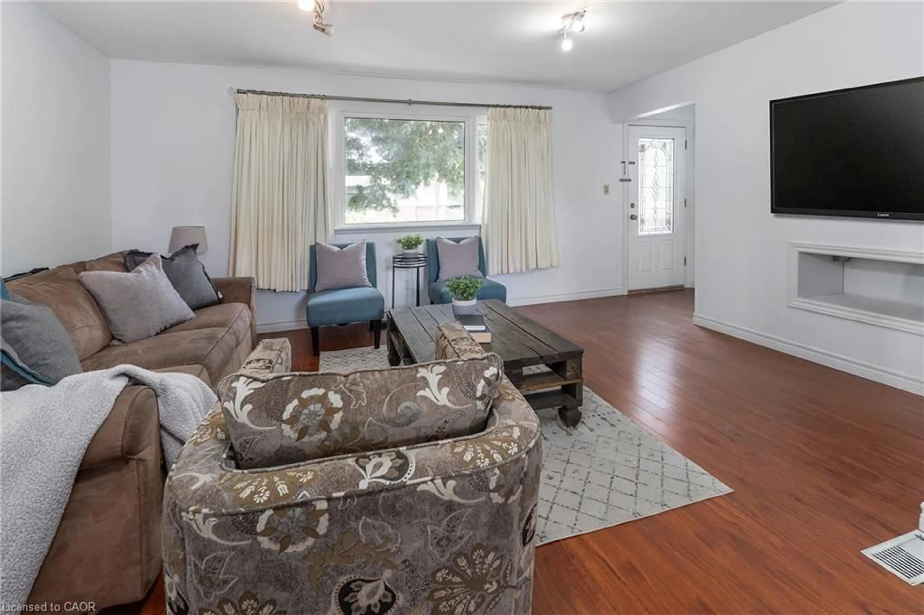 Living room with furniture, wood/laminate floor for 493 Upper Gage Ave, Hamilton Ontario L8V 4J2