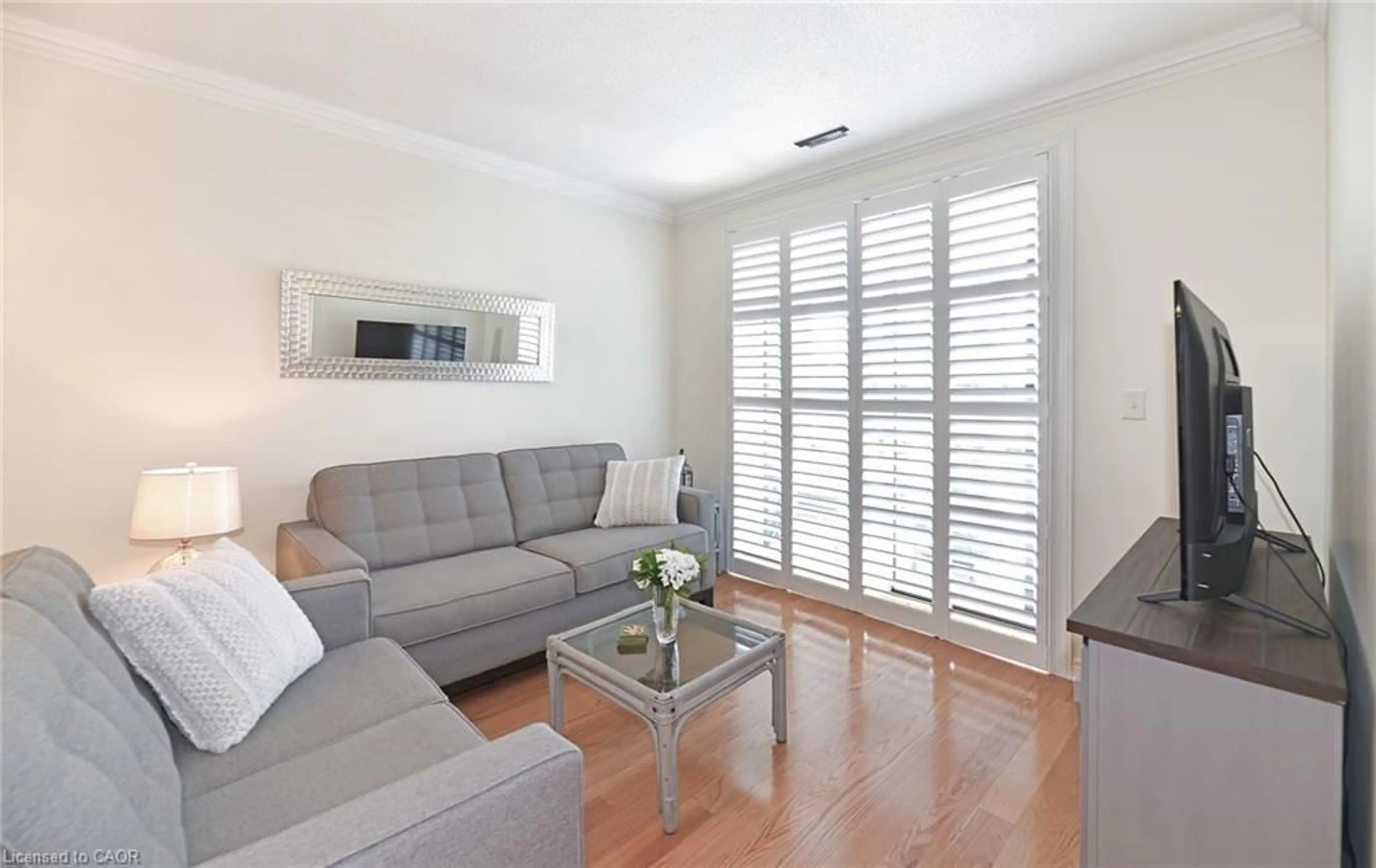 Living room with furniture, wood/laminate floor for 383 Main St #112, Milton Ontario L9T 8K8