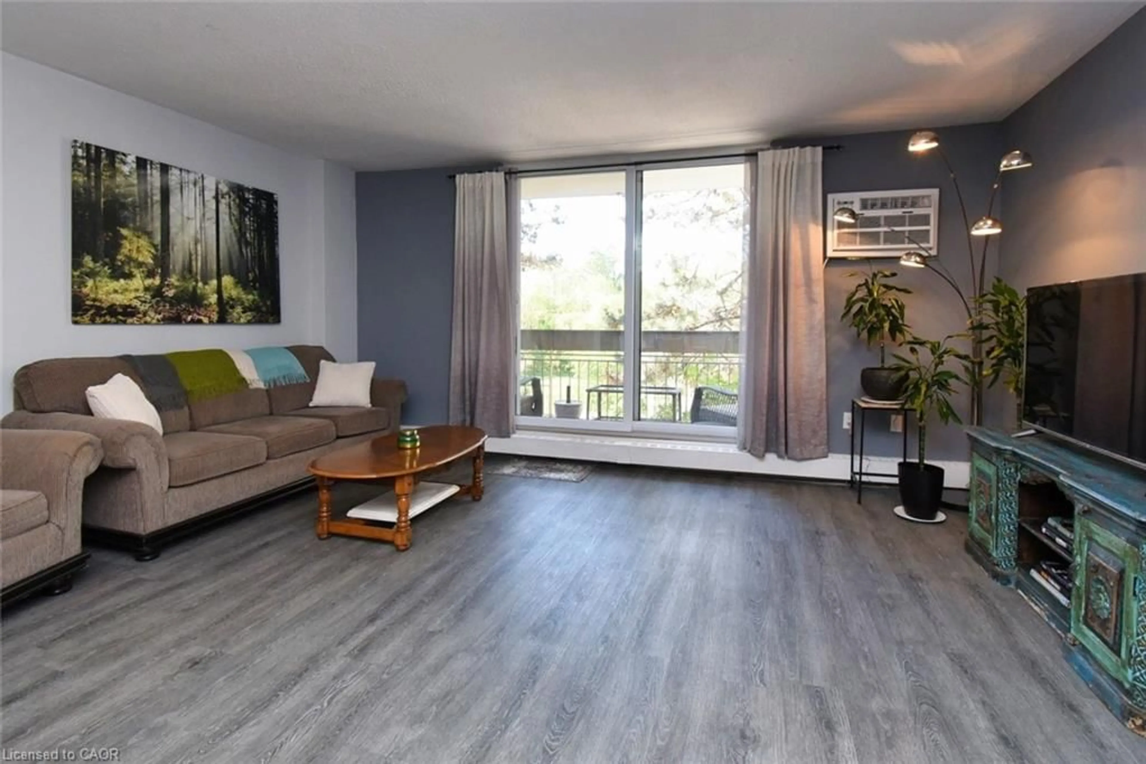 Living room with furniture, wood/laminate floor for 350 Quigley Rd #212, Hamilton Ontario L8K 5N2