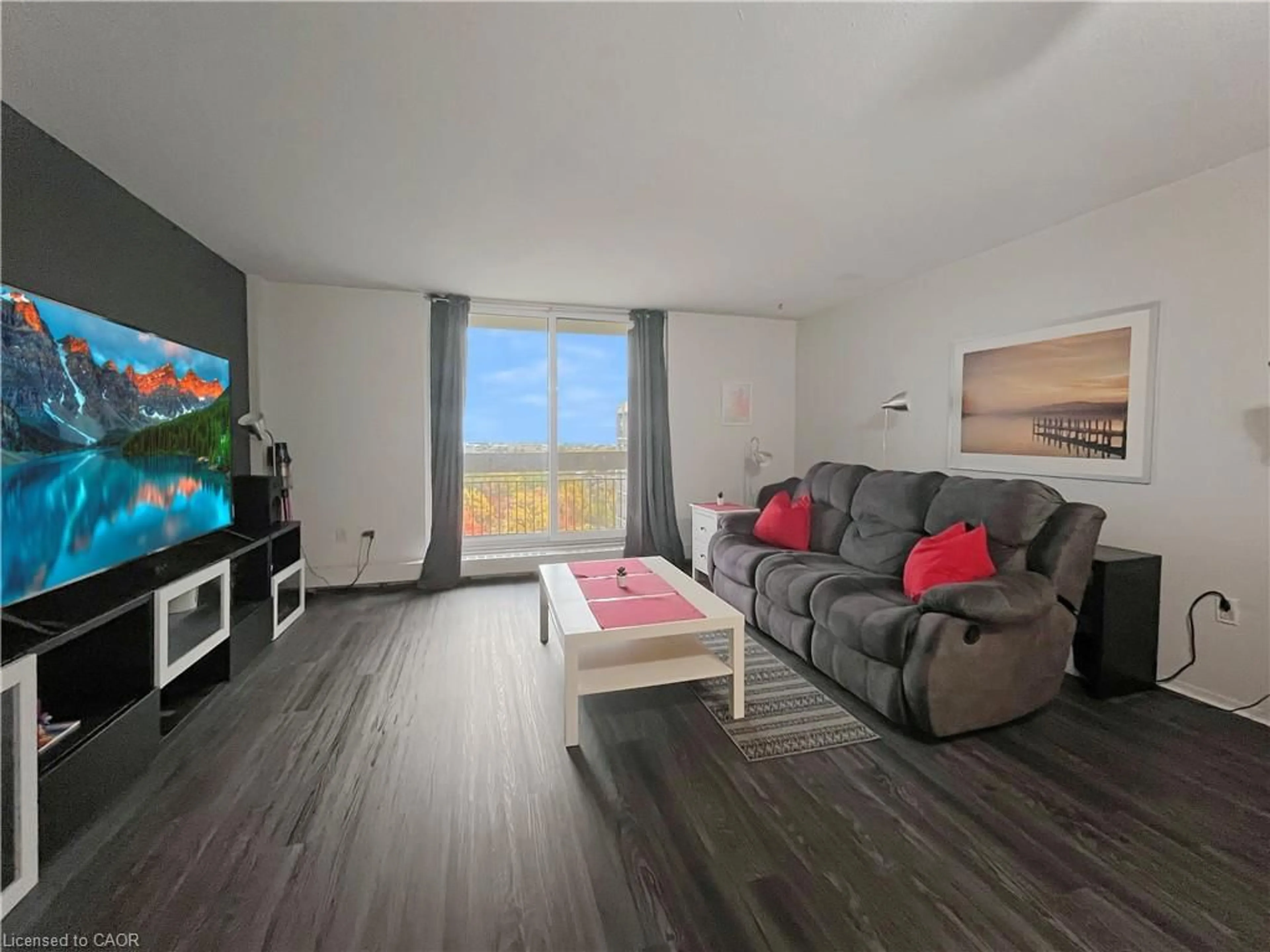 Living room with furniture, wood/laminate floor for 350 Quigley Rd #723, Hamilton Ontario L8K 5N2