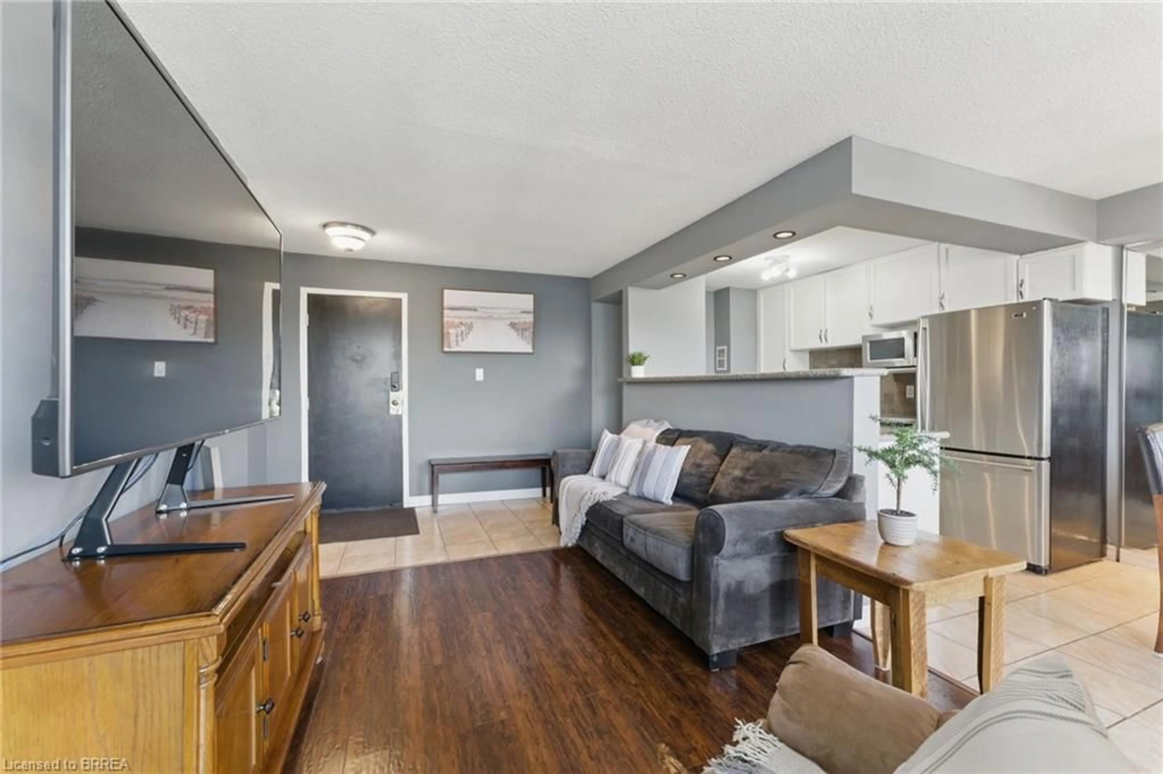 Living room with furniture, wood/laminate floor for 793 Colborne St #401, Brantford Ontario N3S 7J3