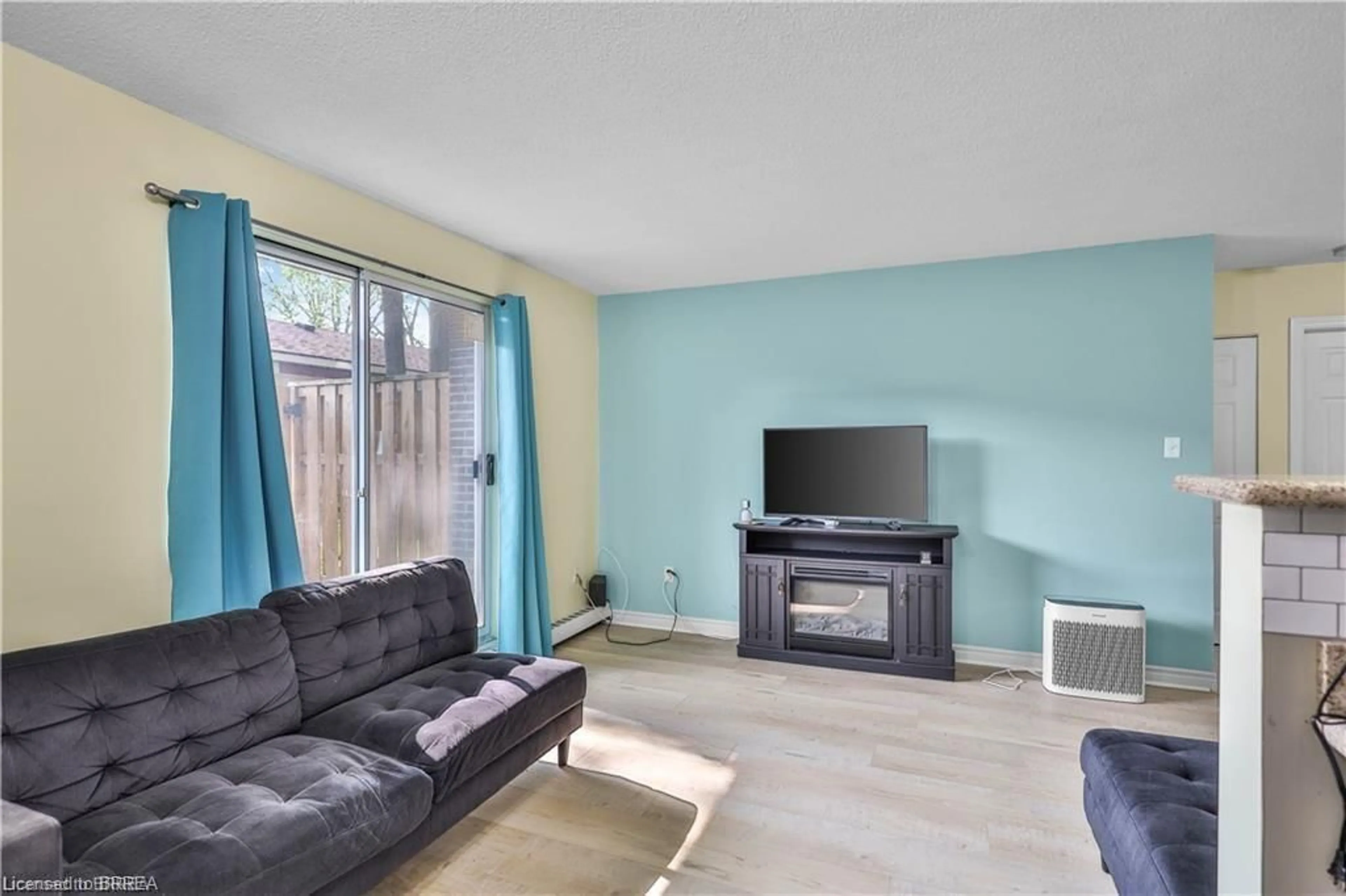 Living room with furniture, wood/laminate floor for 793 Colborne St #104, Brantford Ontario N3S 7J3