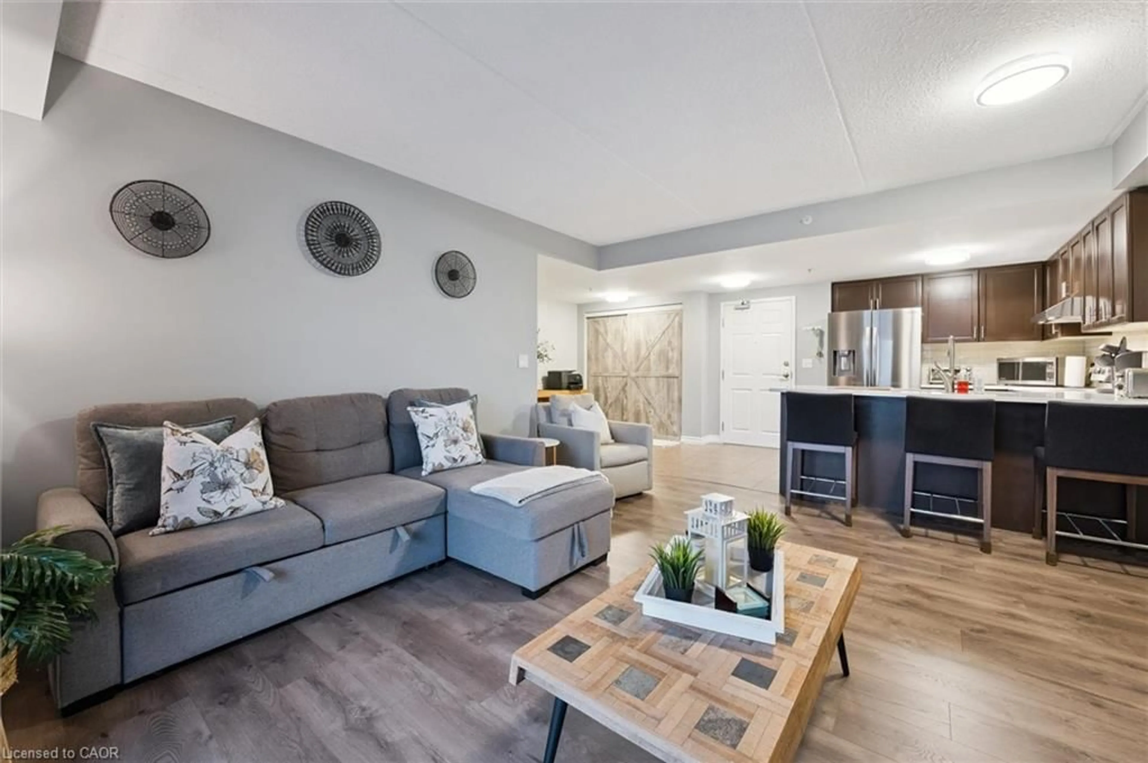 Living room with furniture, wood/laminate floor for 19 Waterford Dr #109, Guelph Ontario N1L 0G8
