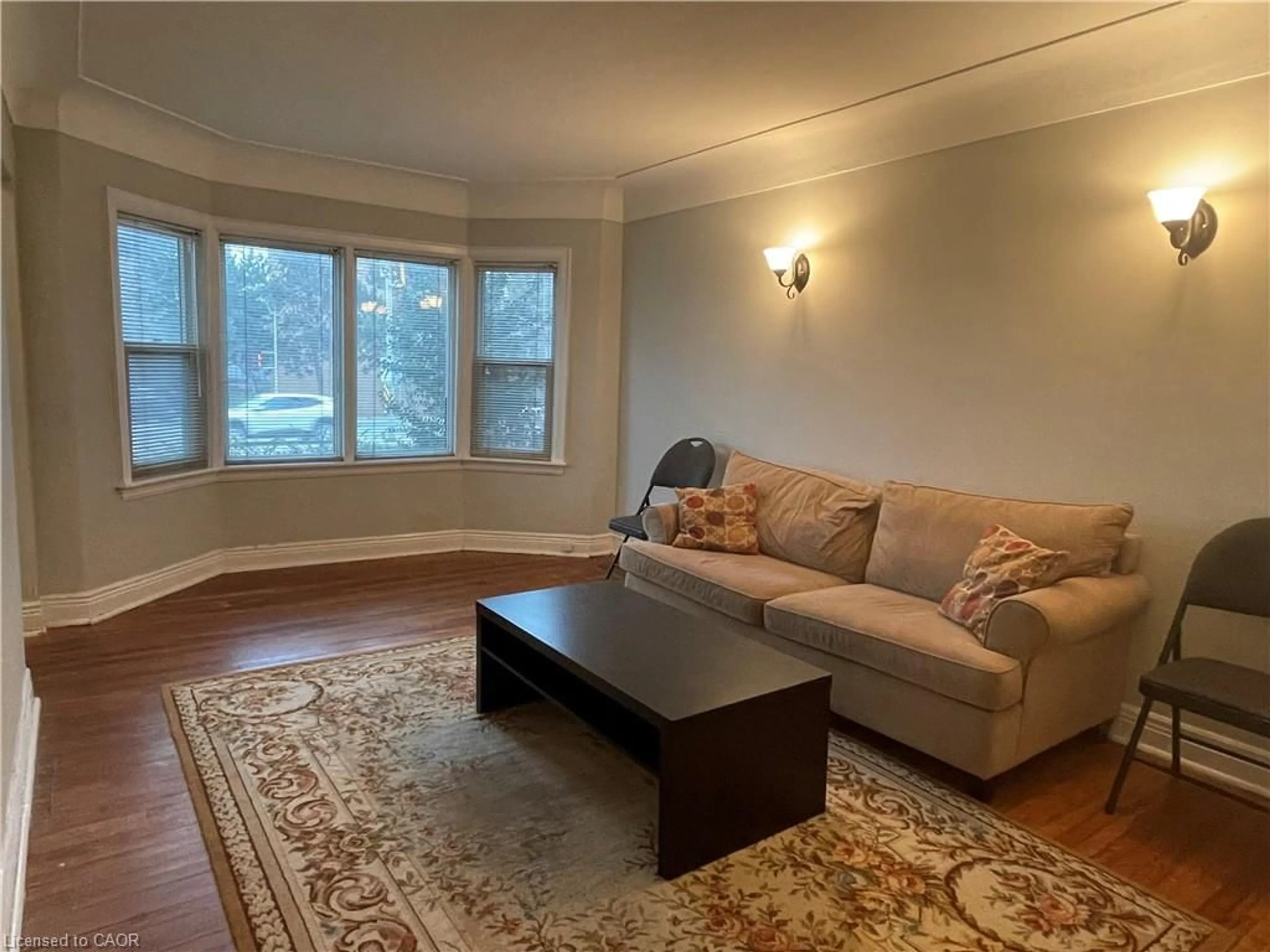 Living room with furniture, wood/laminate floor for 1028 Main St, Hamilton Ontario L8S 1B2
