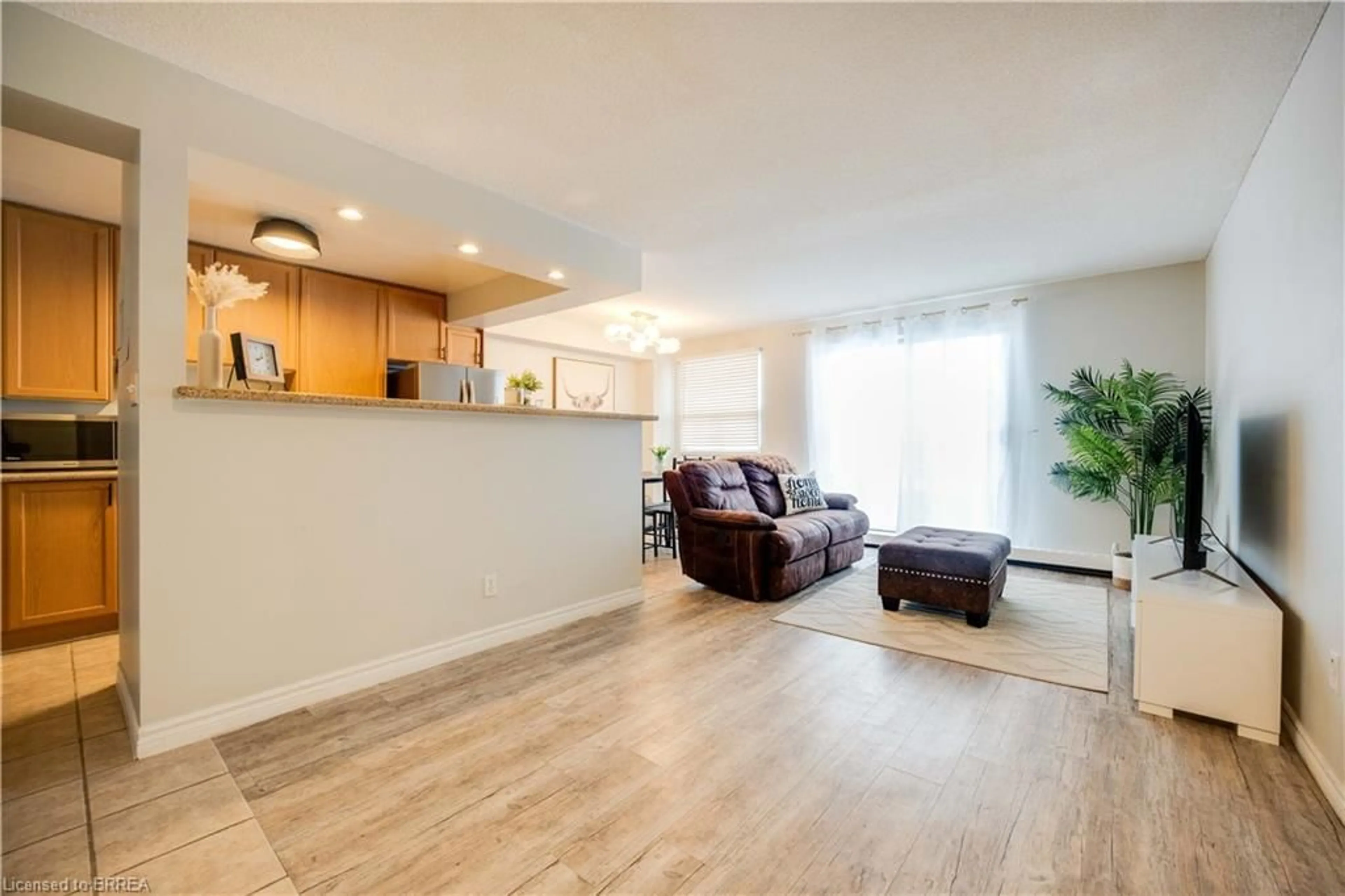 Living room with furniture, wood/laminate floor for 793 Colborne St #304, Brantford Ontario N3S 7J3