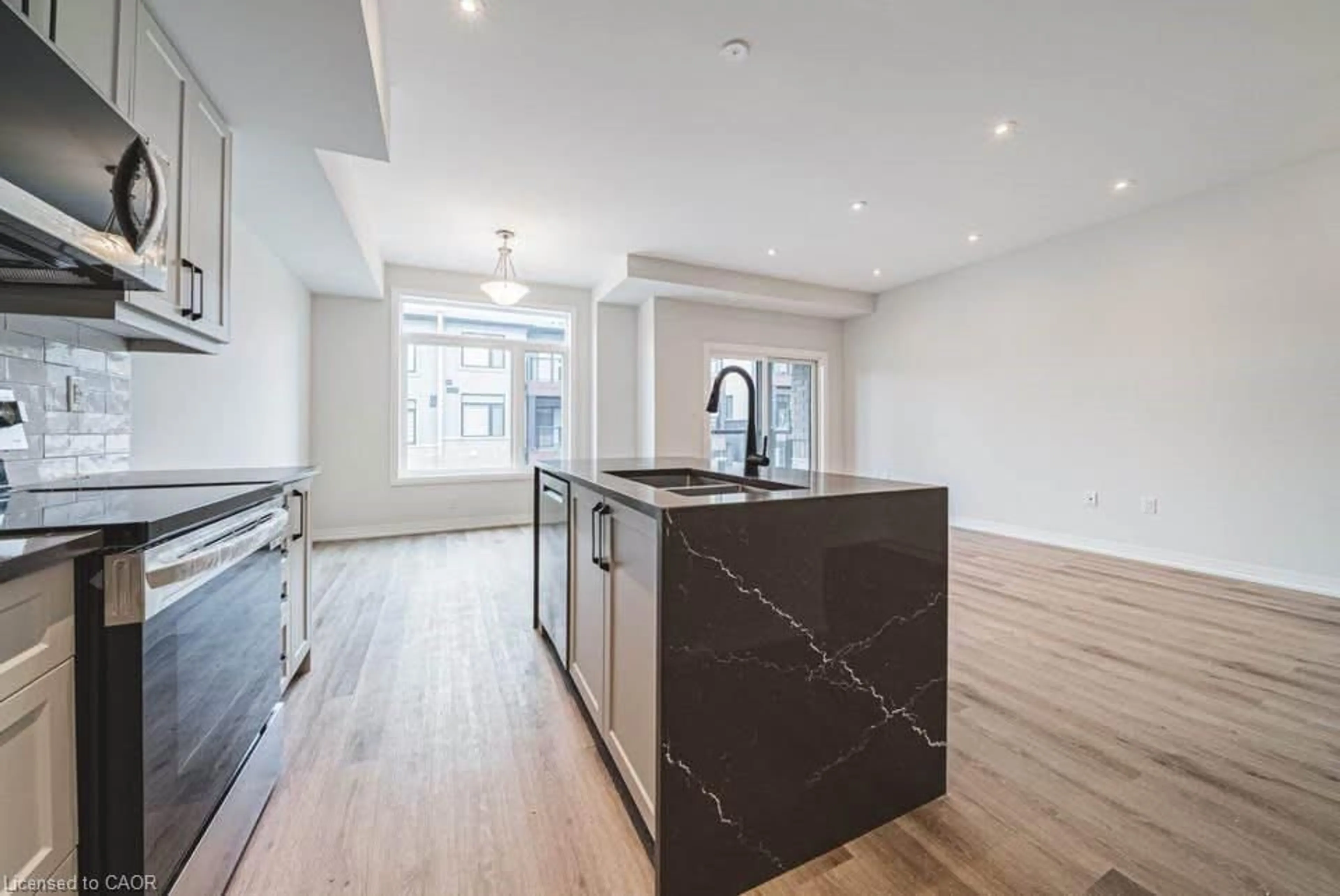 Open concept kitchen, wood/laminate floor for 155 Equestrian Way #131, Cambridge Ontario N3E 0E8