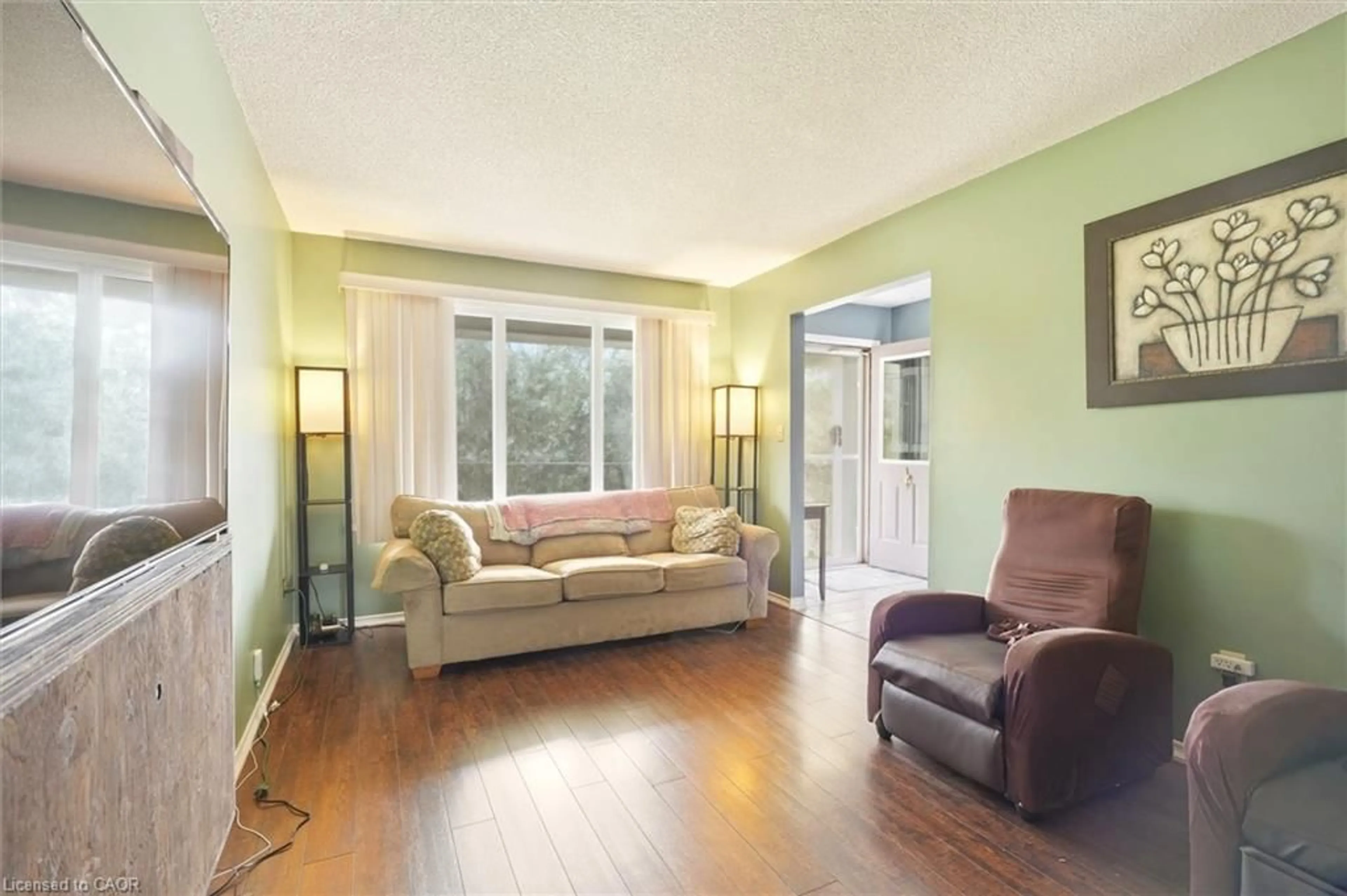 Living room with furniture, wood/laminate floor for 18 Anne Crt, Grimsby Ontario L3M 5B4