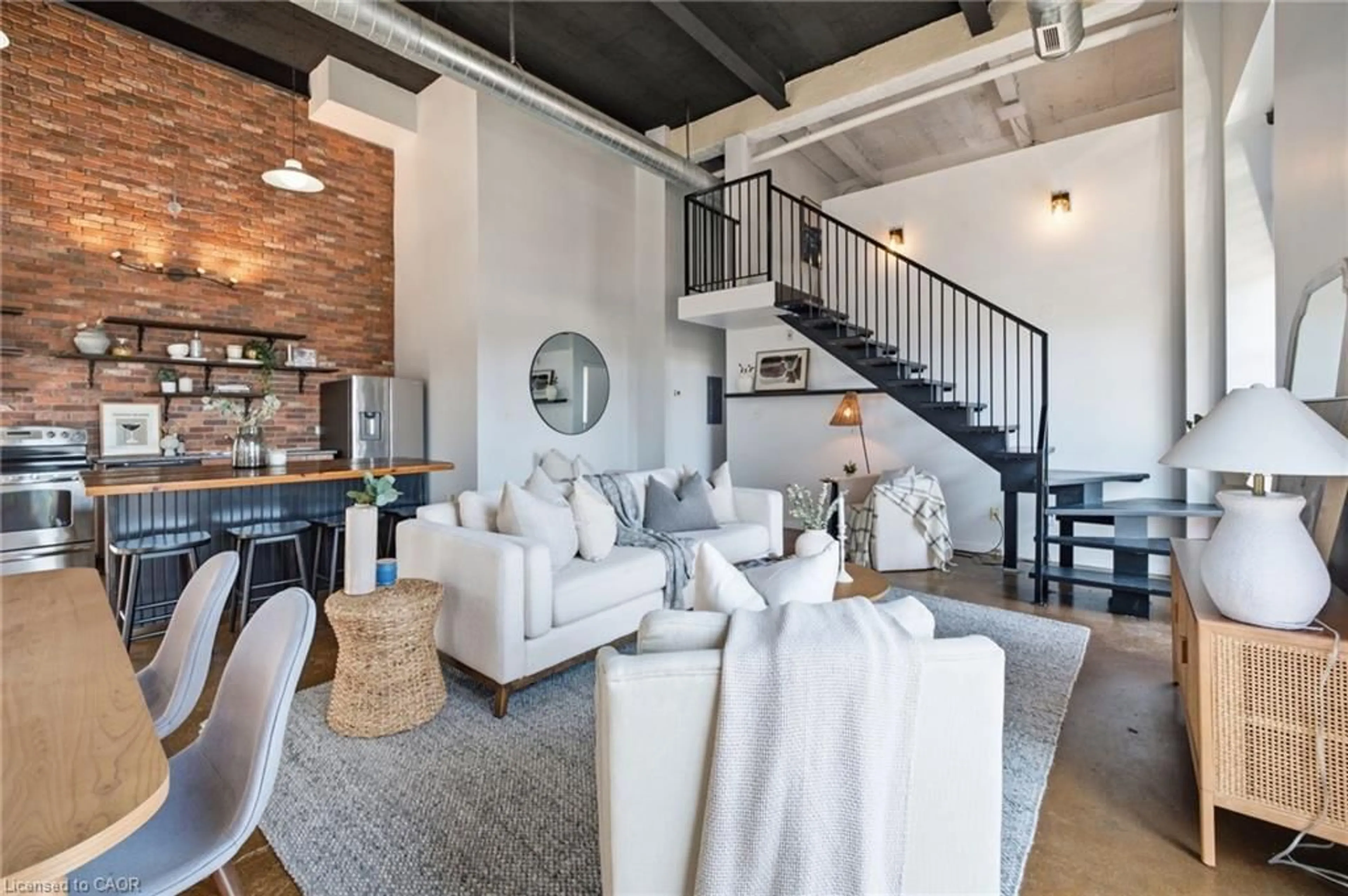 Living room with furniture, cement floor for 11 Rebecca St #410, Hamilton Ontario L8R 3H7