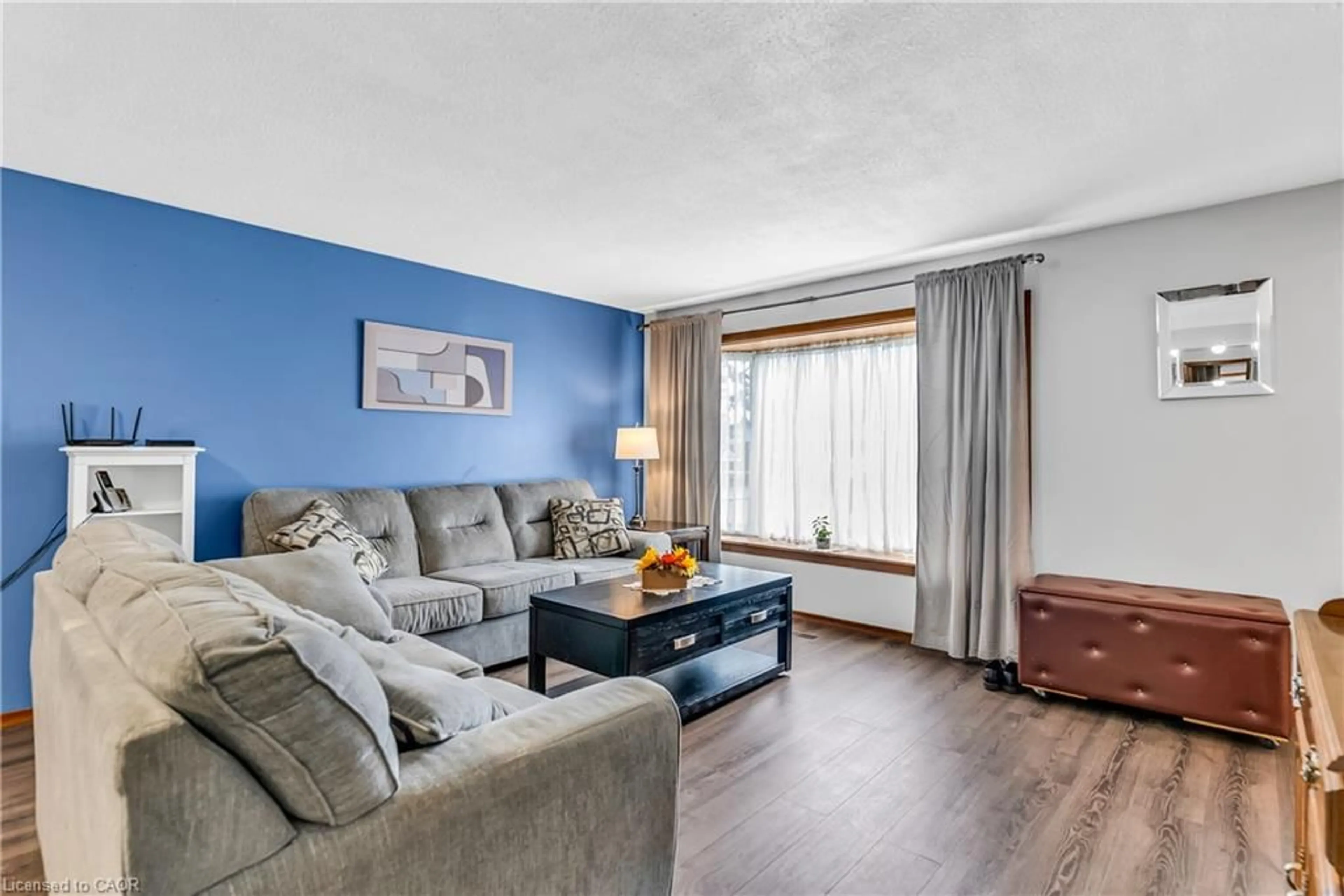 Living room with furniture, wood/laminate floor for 65 Mountford Dr, Guelph Ontario N1E 6E7