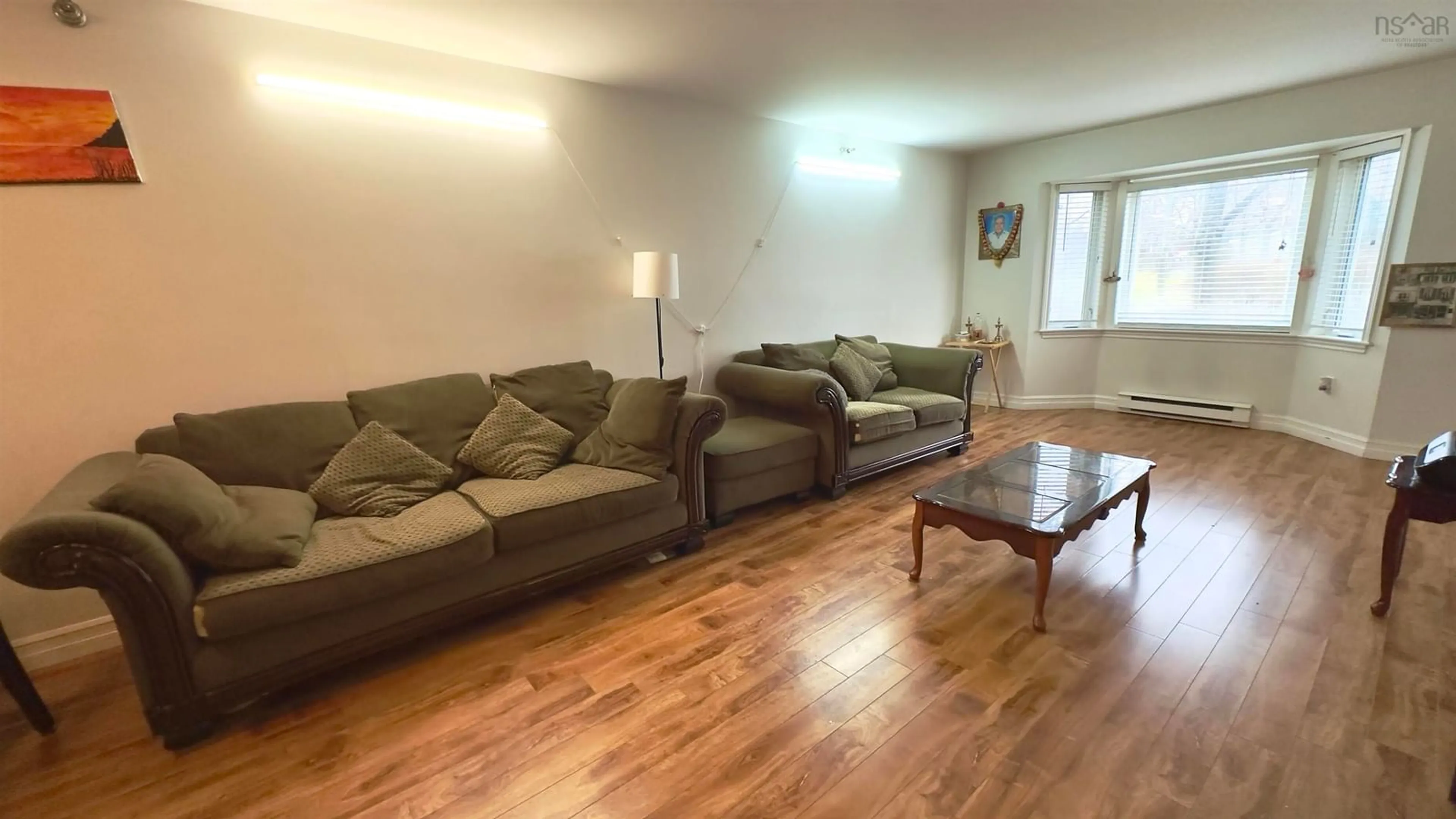 Living room with furniture, wood/laminate floor for 83 Kearney Lake Rd #209, Halifax Nova Scotia B3M 4E6