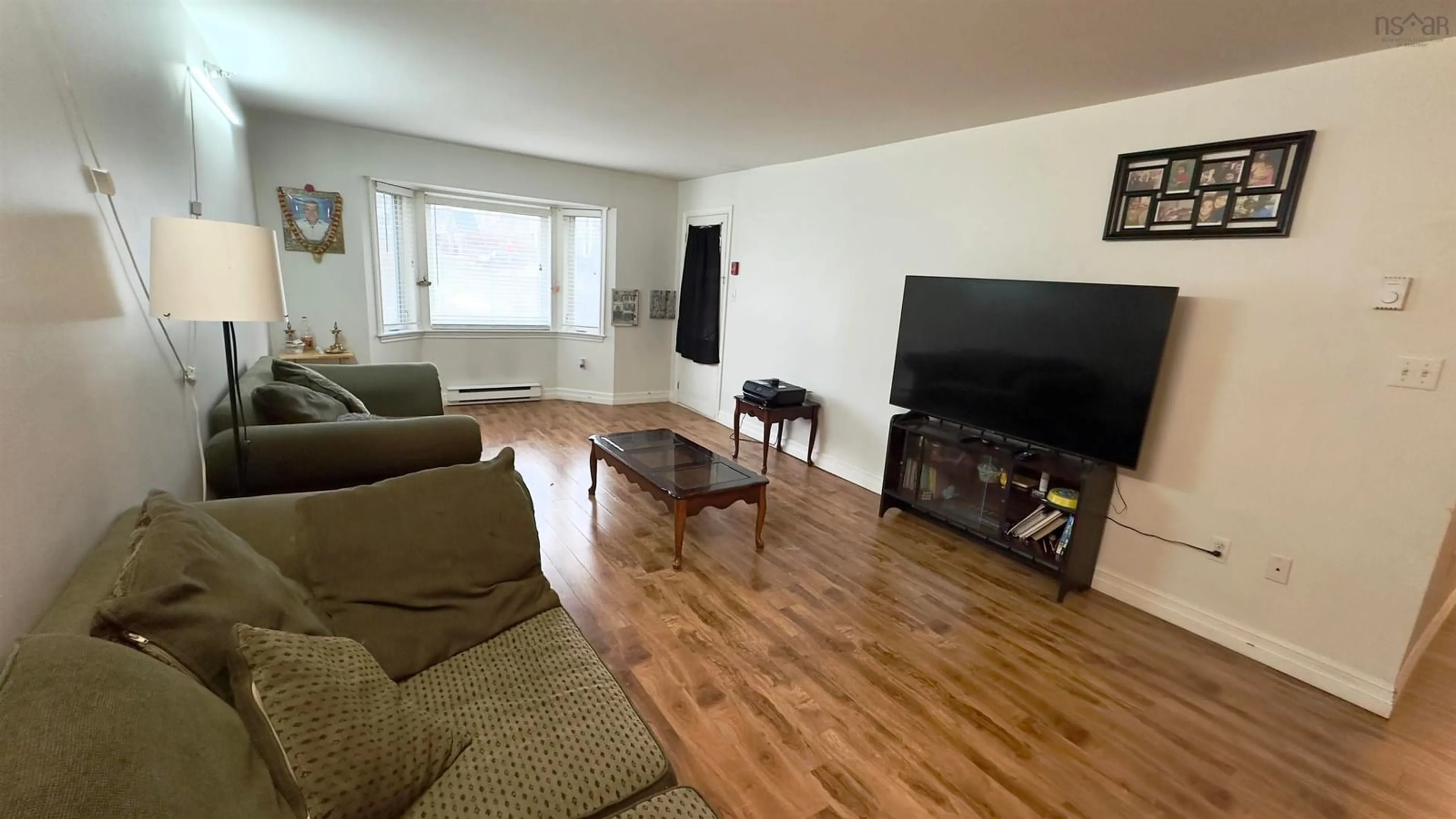 Living room with furniture, wood/laminate floor for 83 Kearney Lake Rd #209, Halifax Nova Scotia B3M 4E6