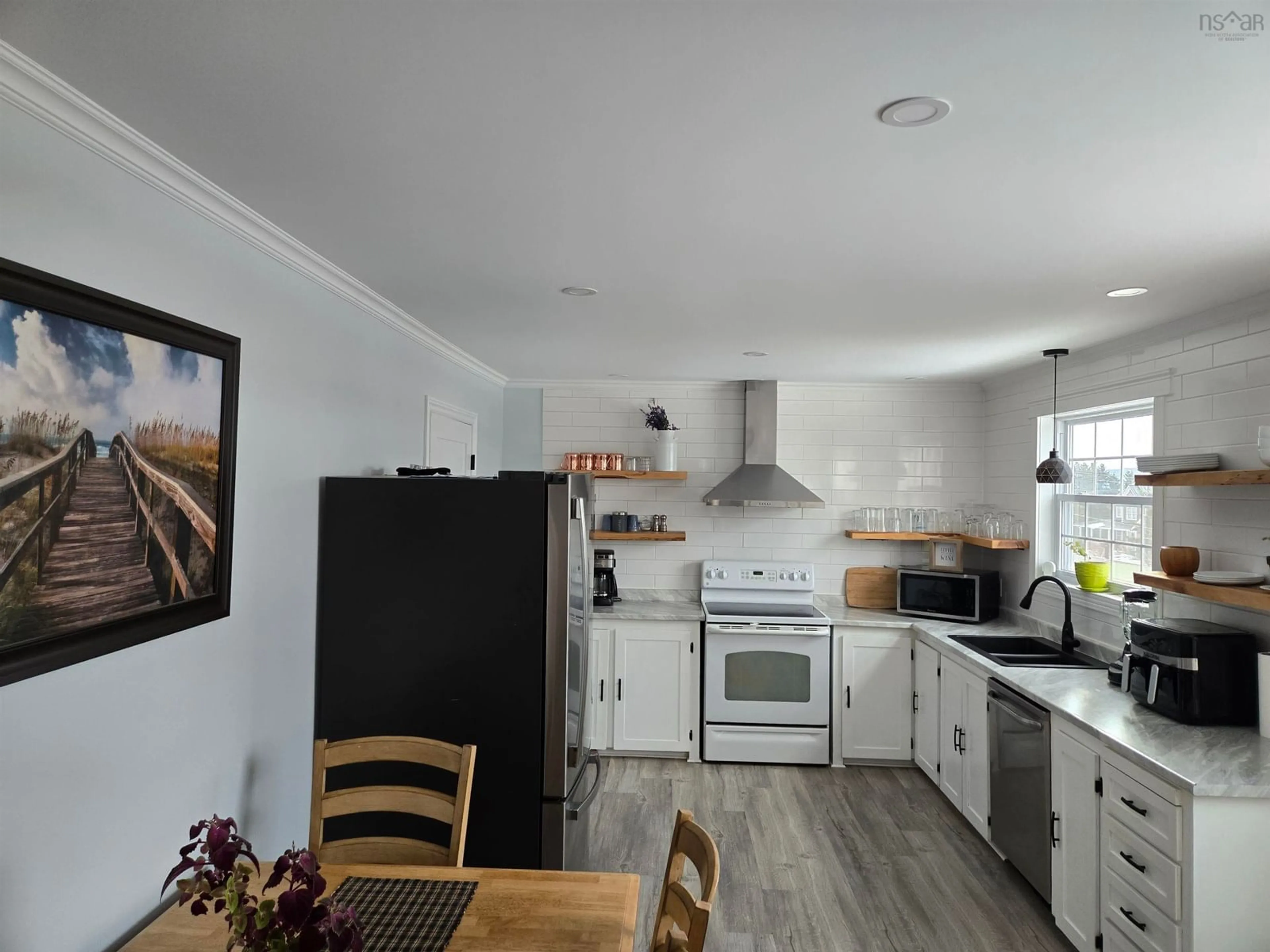 Open concept kitchen, wood/laminate floor for 20 Evelyns Ave, Georges River Nova Scotia B1Y 3G6