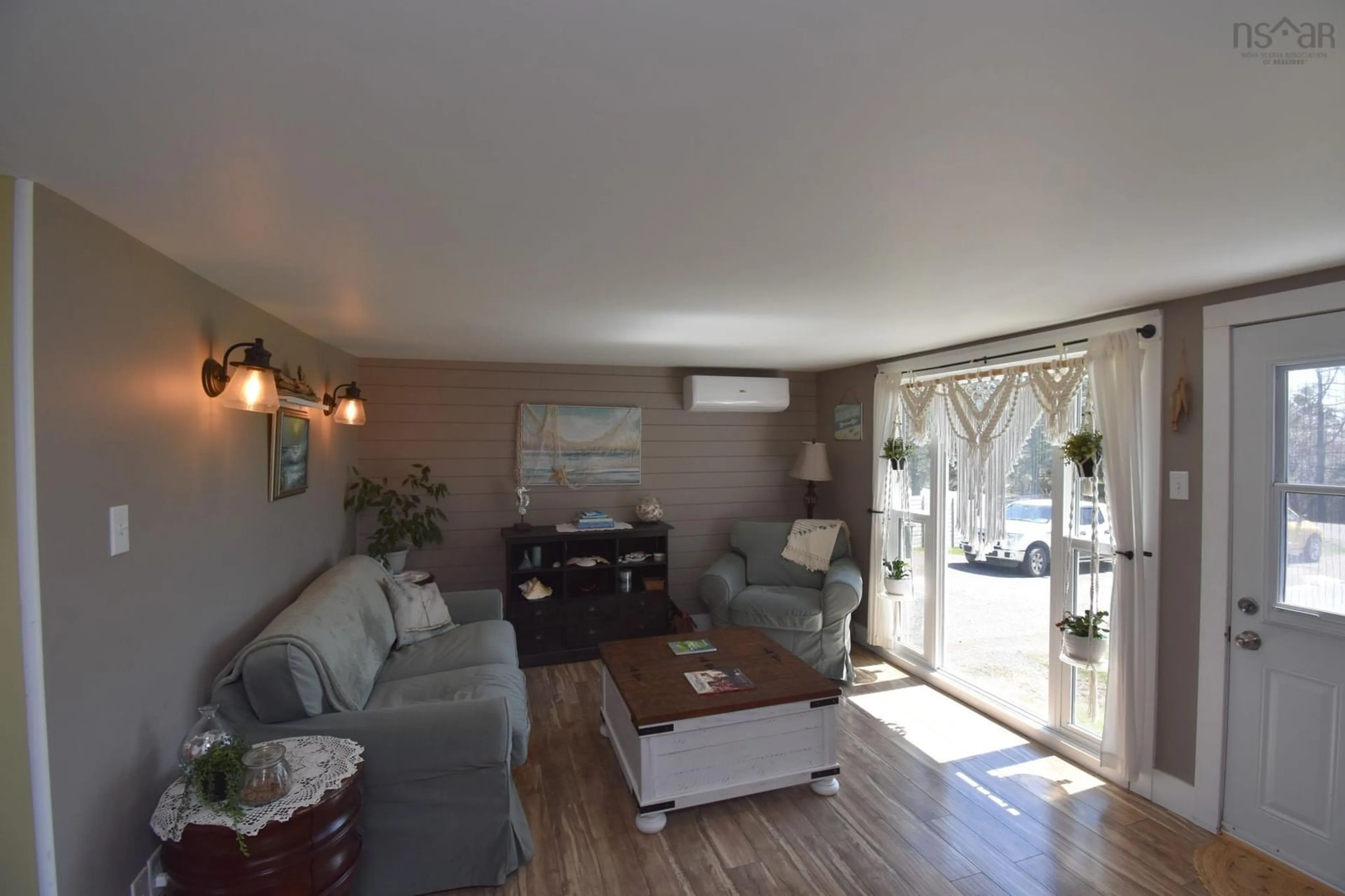 Living room with furniture, wood/laminate floor for 683 Shore Rd, Masstown Nova Scotia B0M 1G0