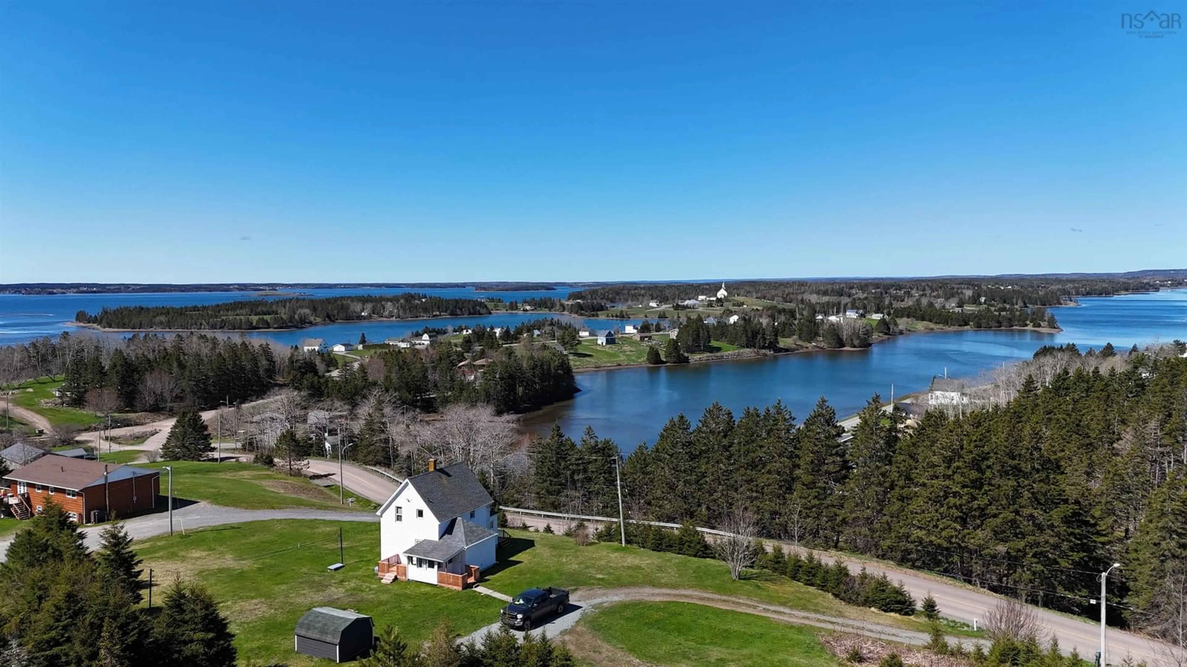 A pic from outside/outdoor area/front of a property/back of a property/a pic from drone, water/lake/river/ocean view for 95 Church Point Road, River Bourgeois Nova Scotia B0E 2X0