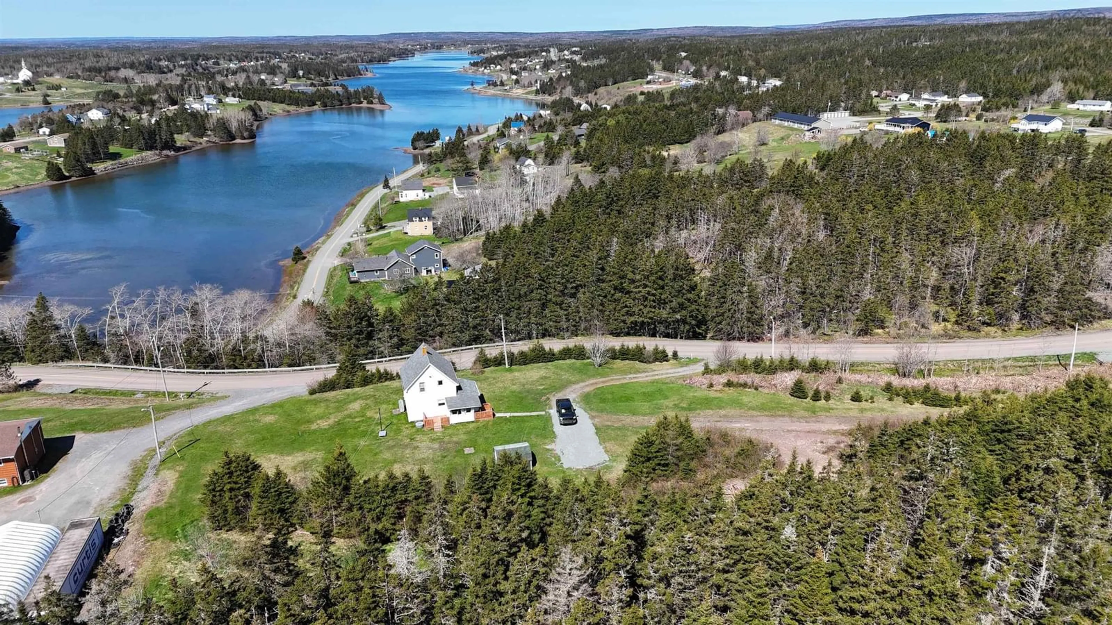 A pic from outside/outdoor area/front of a property/back of a property/a pic from drone, water/lake/river/ocean view for 95 Church Point Road, River Bourgeois Nova Scotia B0E 2X0