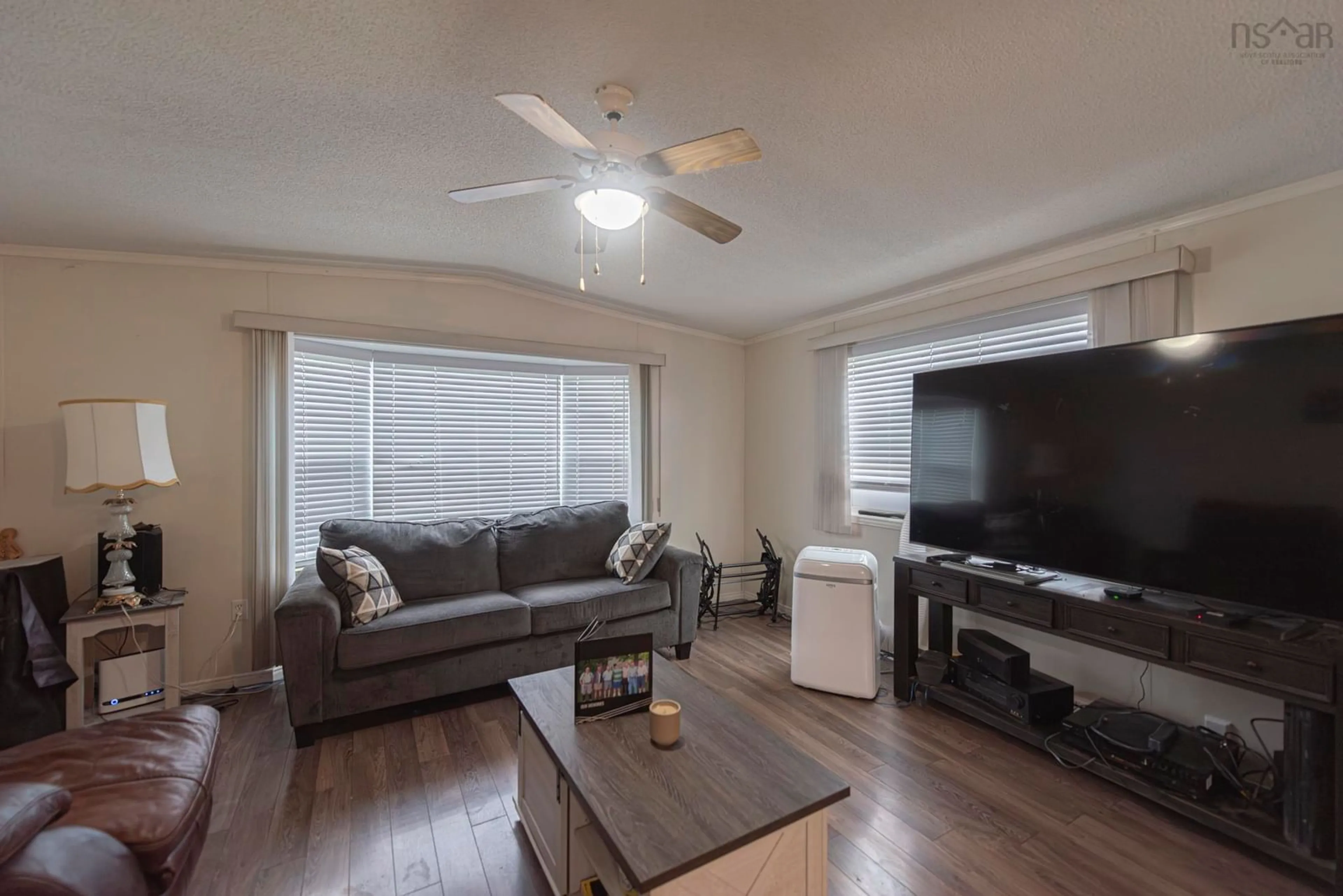 Living room with furniture, wood/laminate floor for 10 High Street Estates, New Glasgow Nova Scotia B2H 4B8