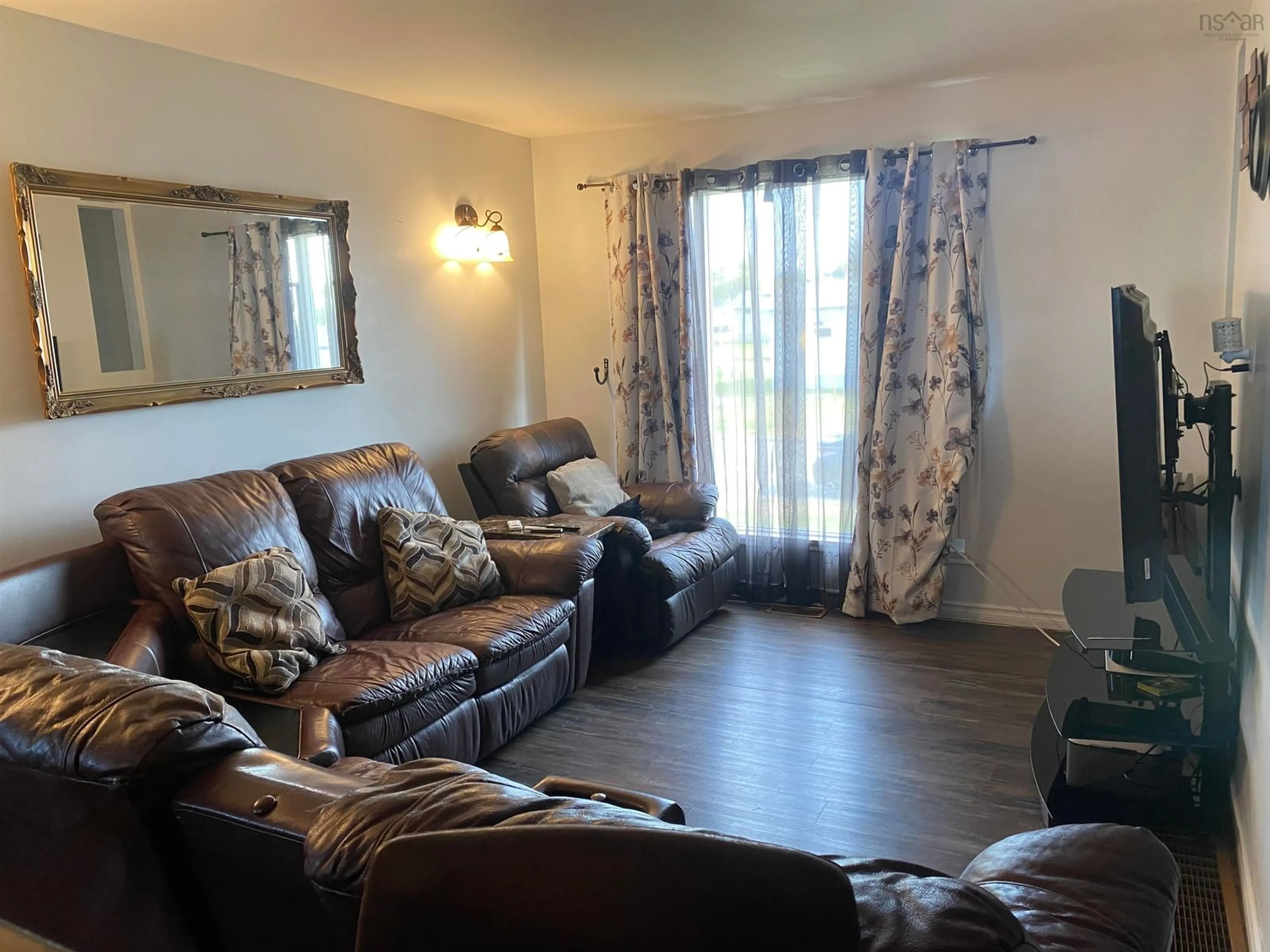 Living room with furniture, wood/laminate floor for 24 Notre Dame St, Sydney Mines Nova Scotia B1V 2R7
