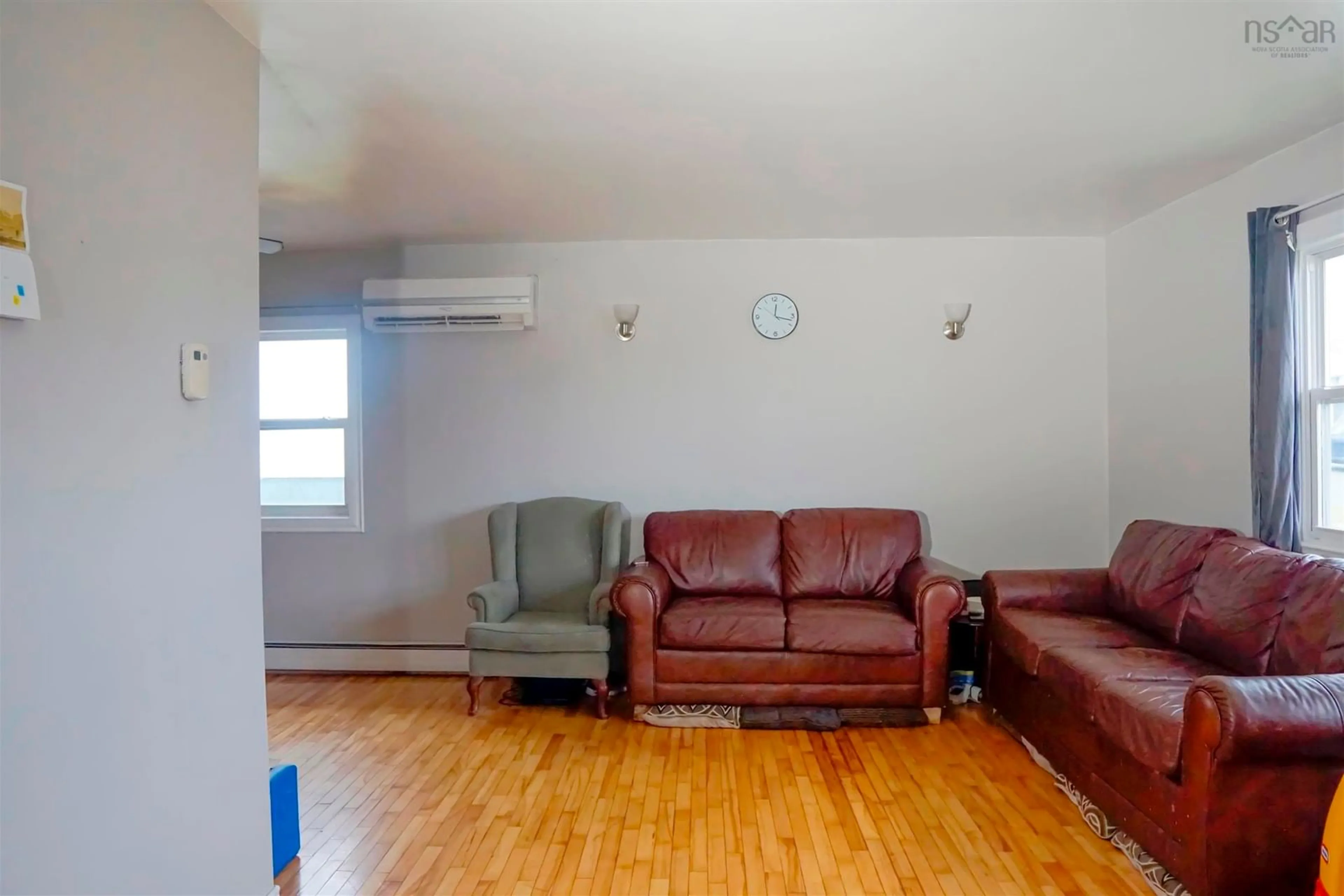 Living room with furniture, wood/laminate floor for 32 Common St, Sydney Nova Scotia B1P 3L1