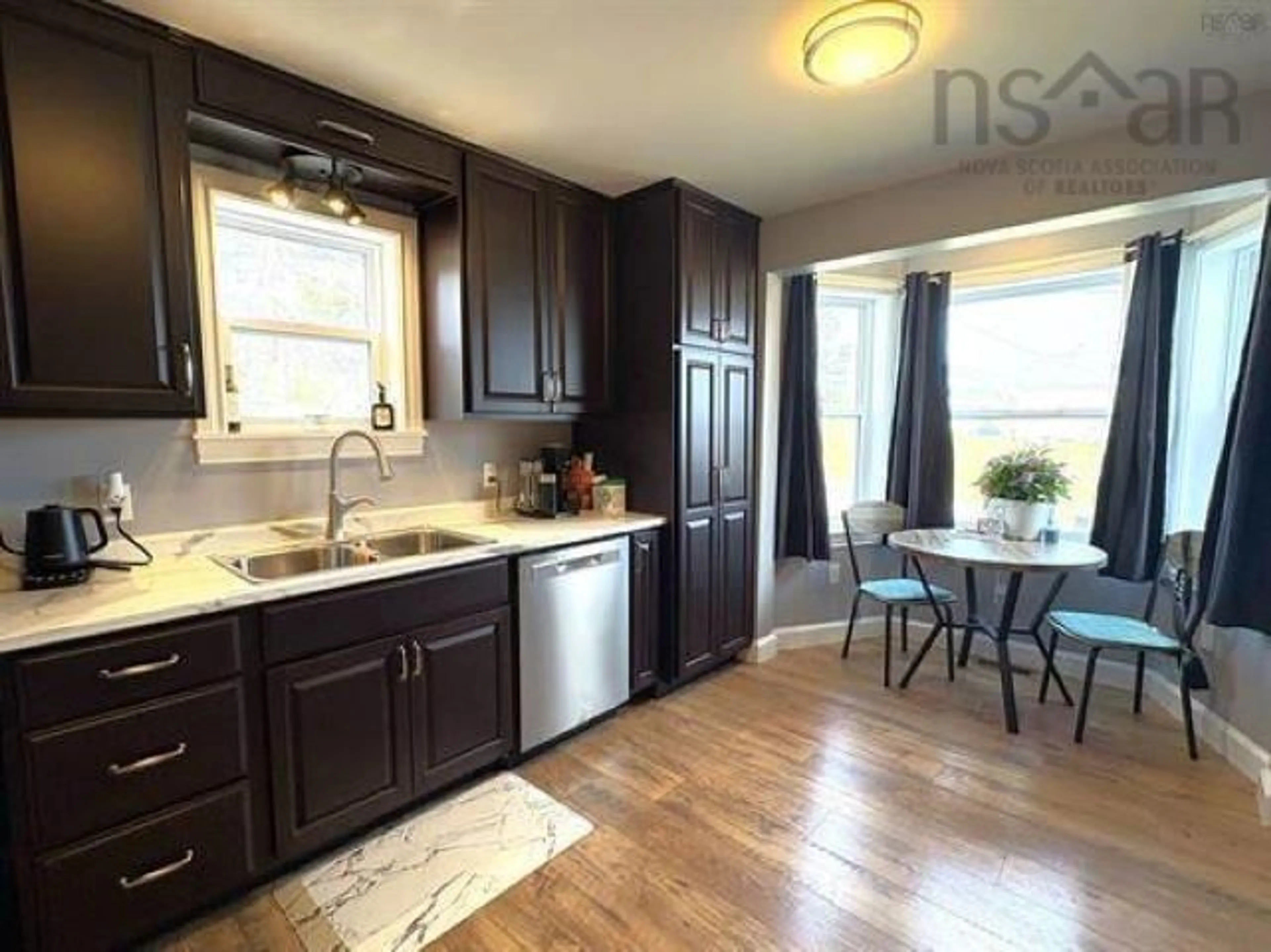Open concept kitchen, wood/laminate floor for 21 Marconi St, Louisbourg Nova Scotia B1C 1K2
