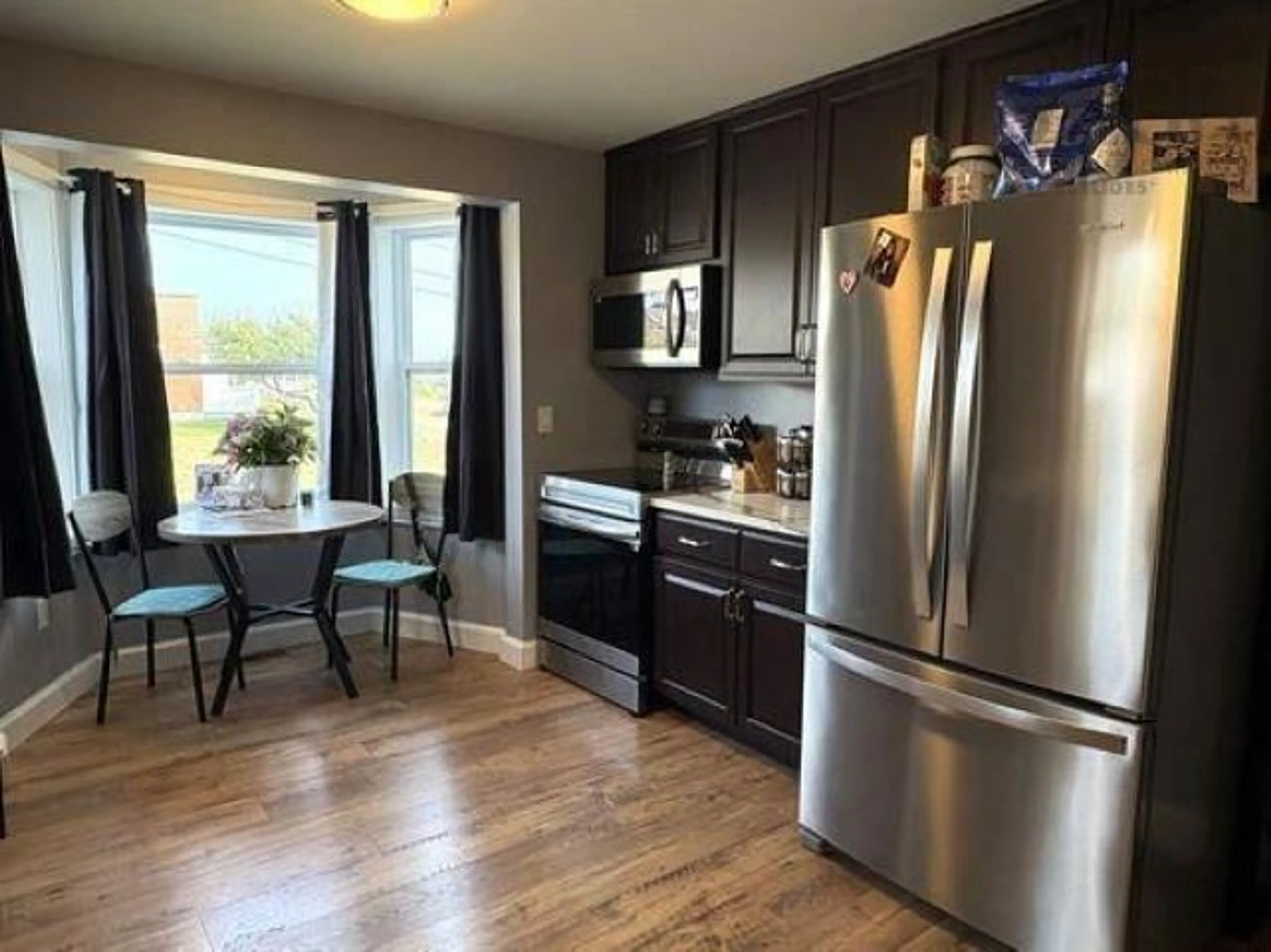 Open concept kitchen, wood/laminate floor for 21 Marconi St, Louisbourg Nova Scotia B1C 1K2