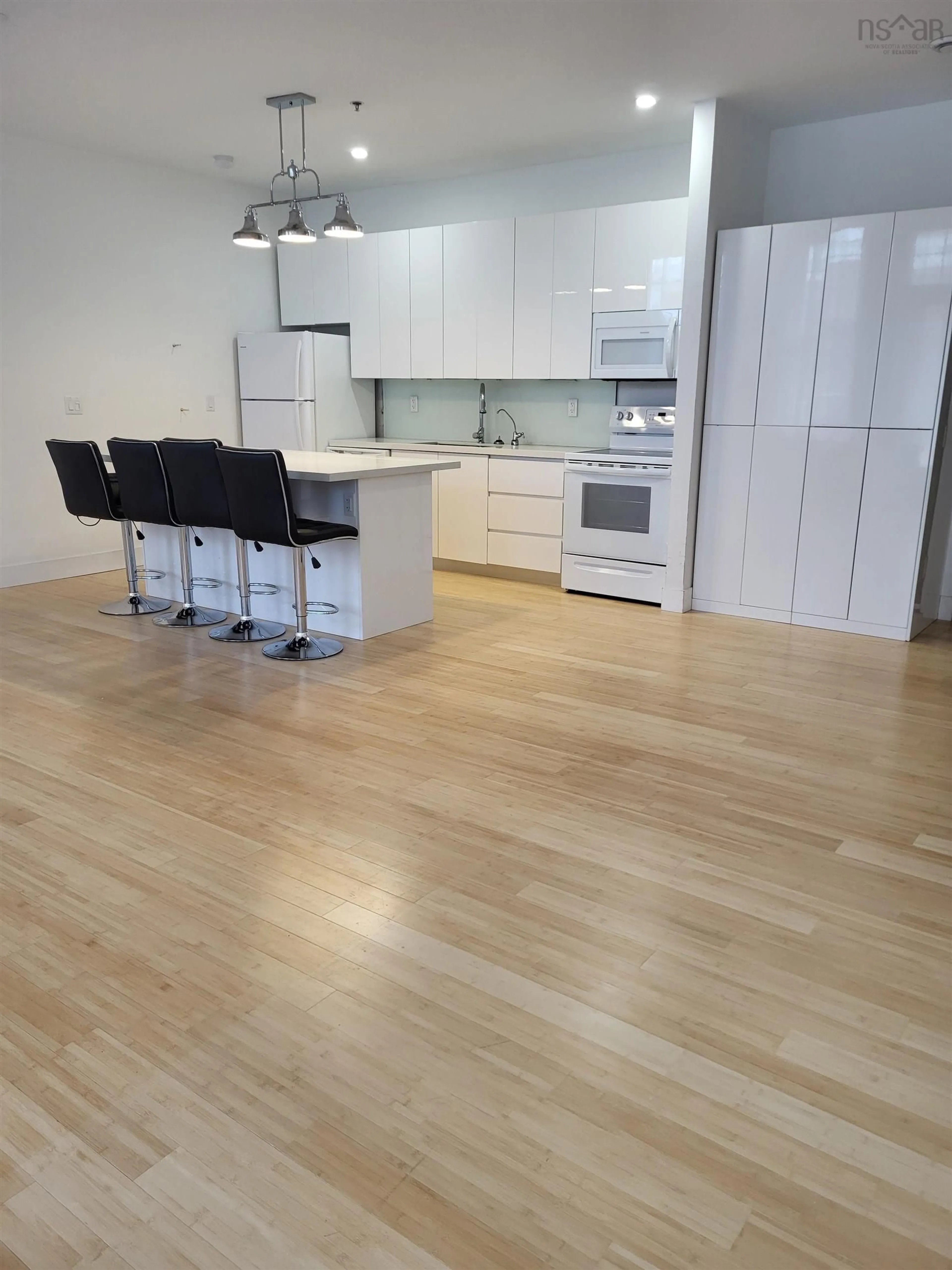 Open concept kitchen, wood/laminate floor for 151 Ritchie St #211, Annapolis Royal Nova Scotia B0S 1A0